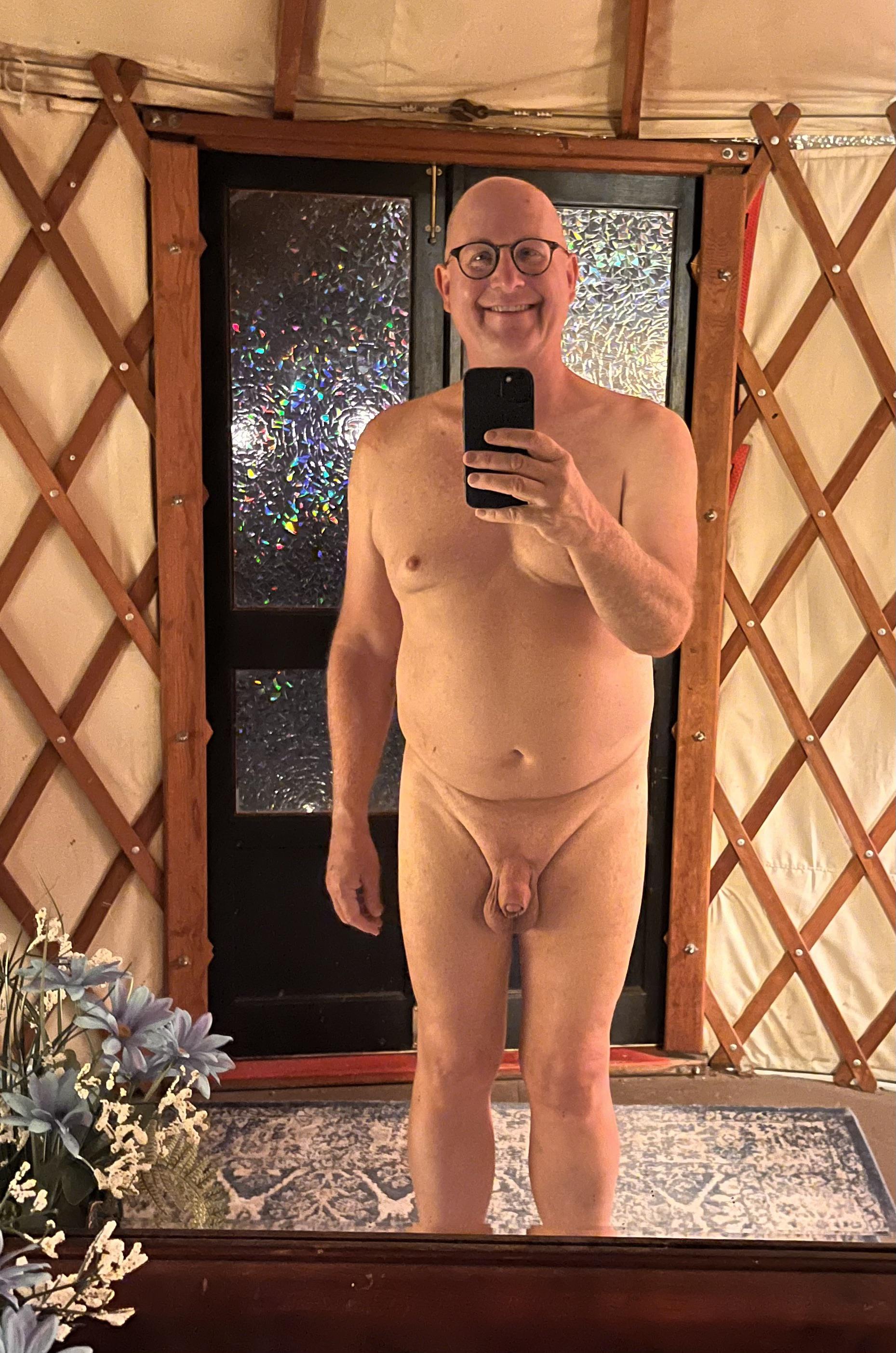 Bald mature white man posing nude outdoors and in a yurt at a nudist resort.