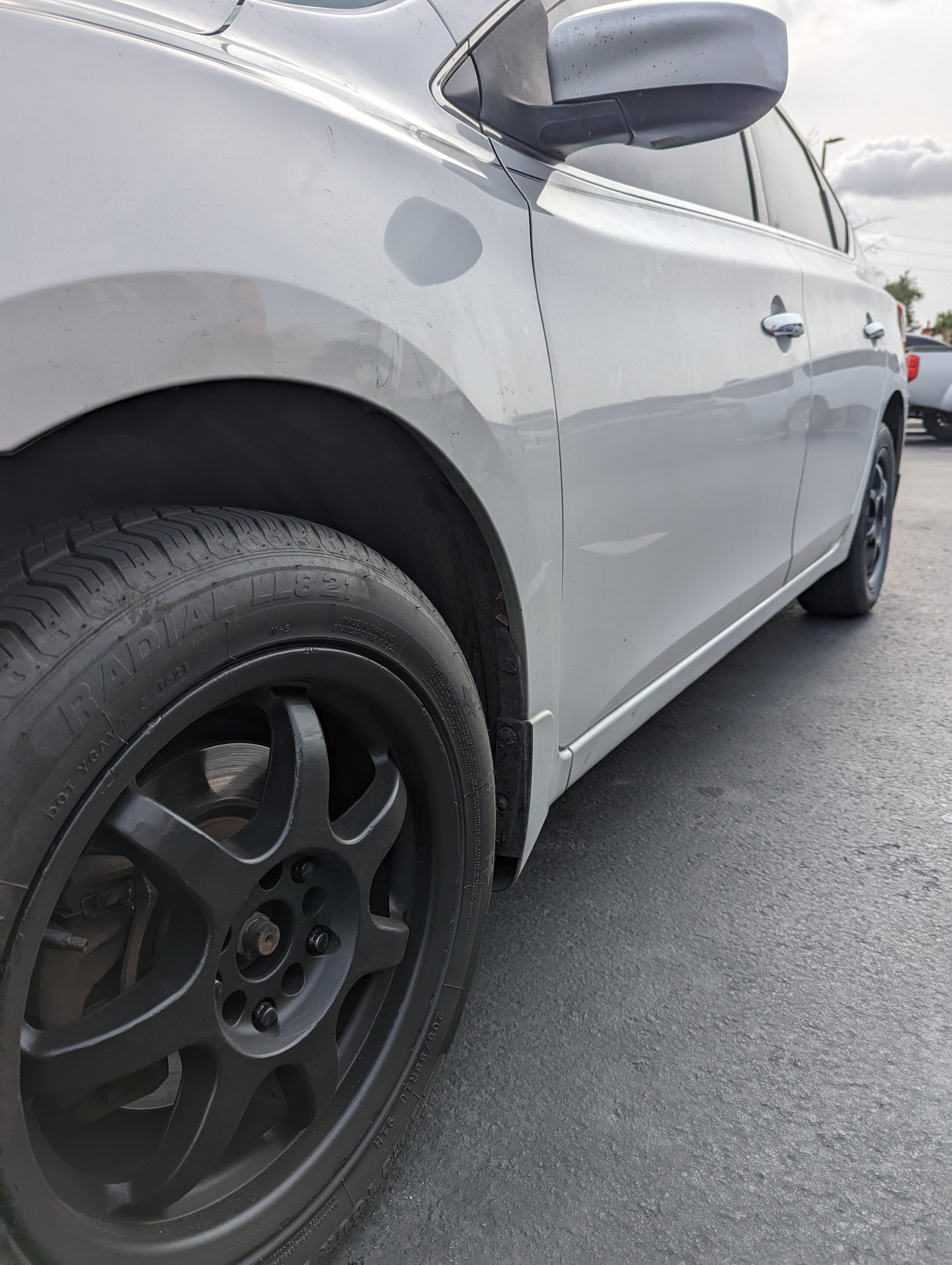 Close-up of a silver Nissan car parked on grass