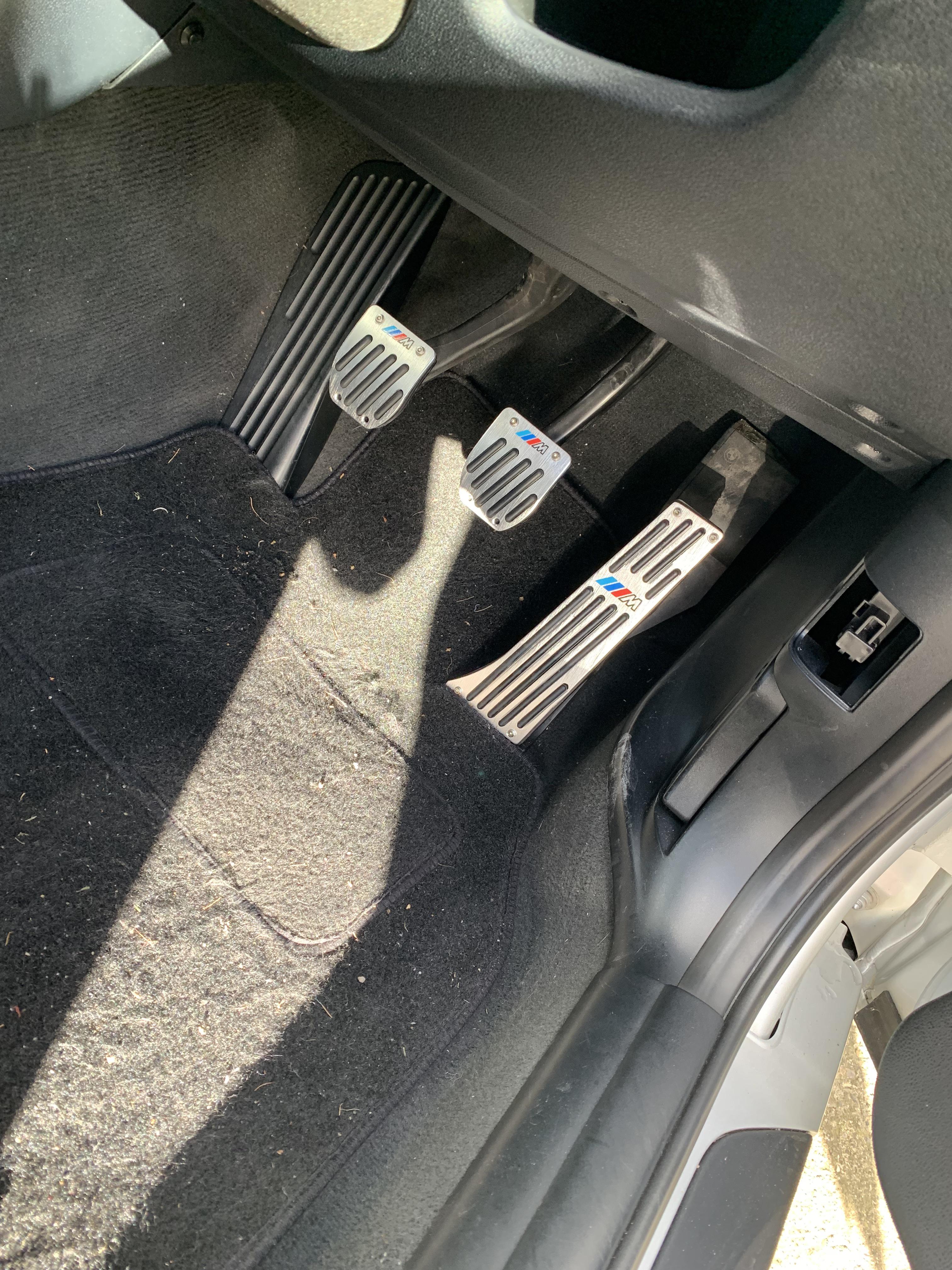 Silver BMW 120i car exterior and interior footwell with pedals