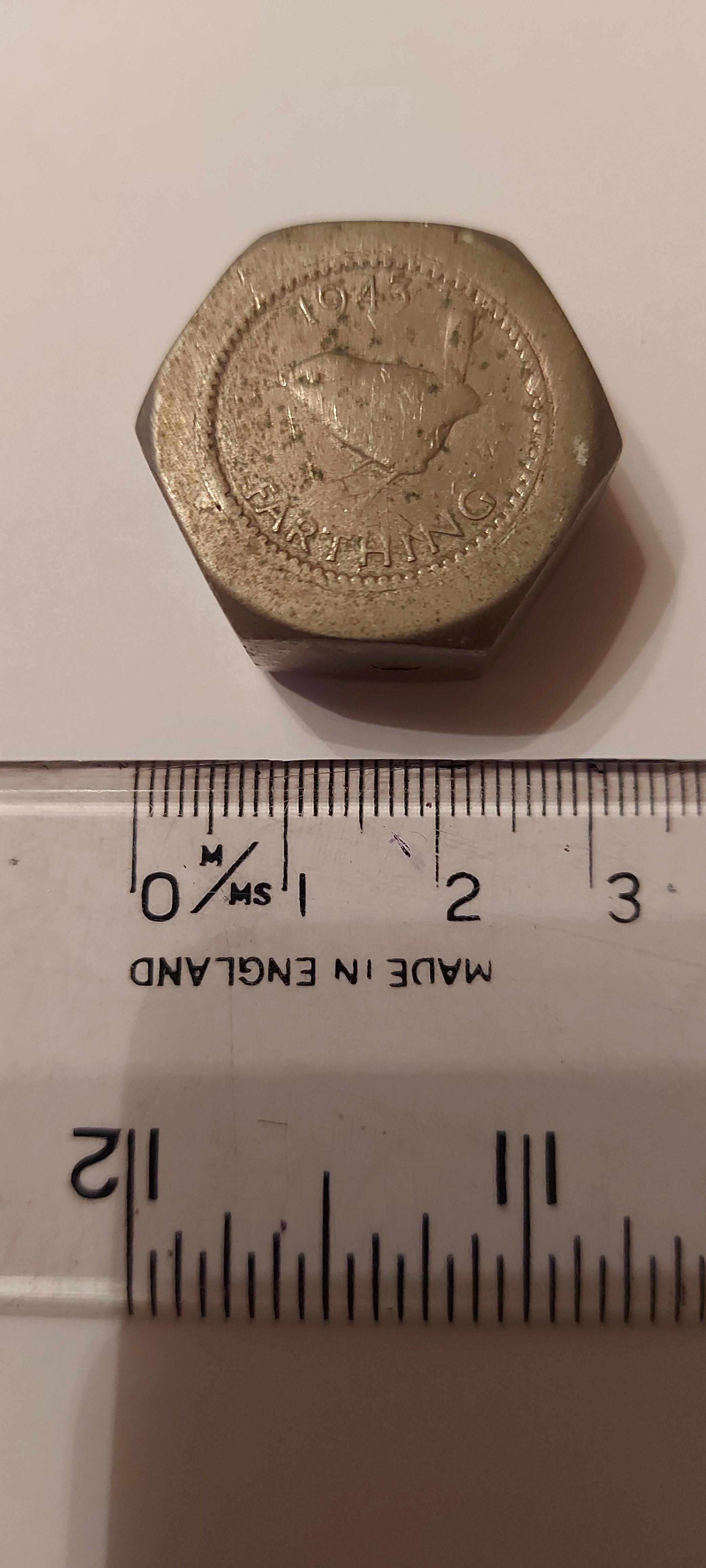 Does anyone know what this is? Looks like a solid nut with a farthing ...