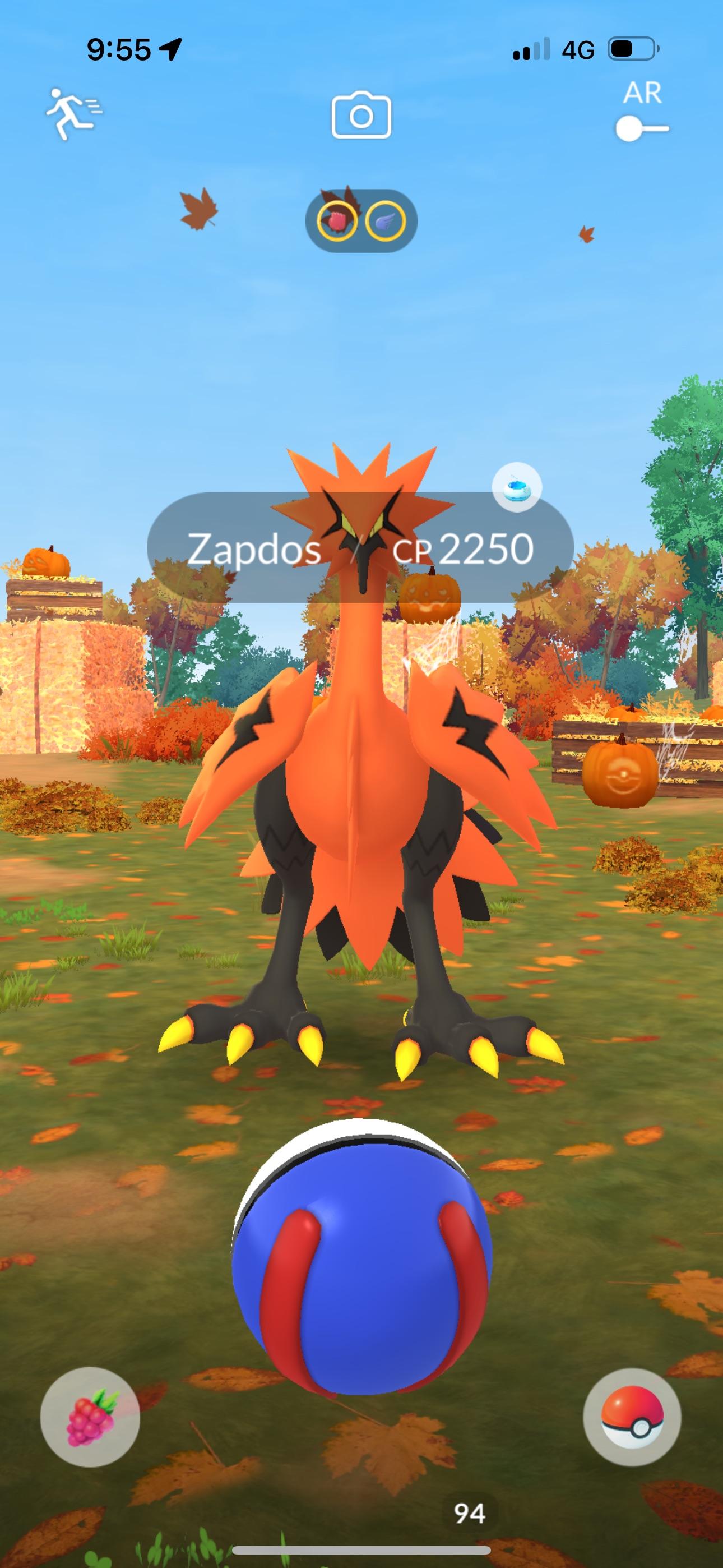 Orange Zapdos and a Pokéball in an autumn landscape with pumpkins and fall leaves from Pokémon GO