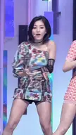 Jihyo performing a dance routine on stage in a floral mini dress