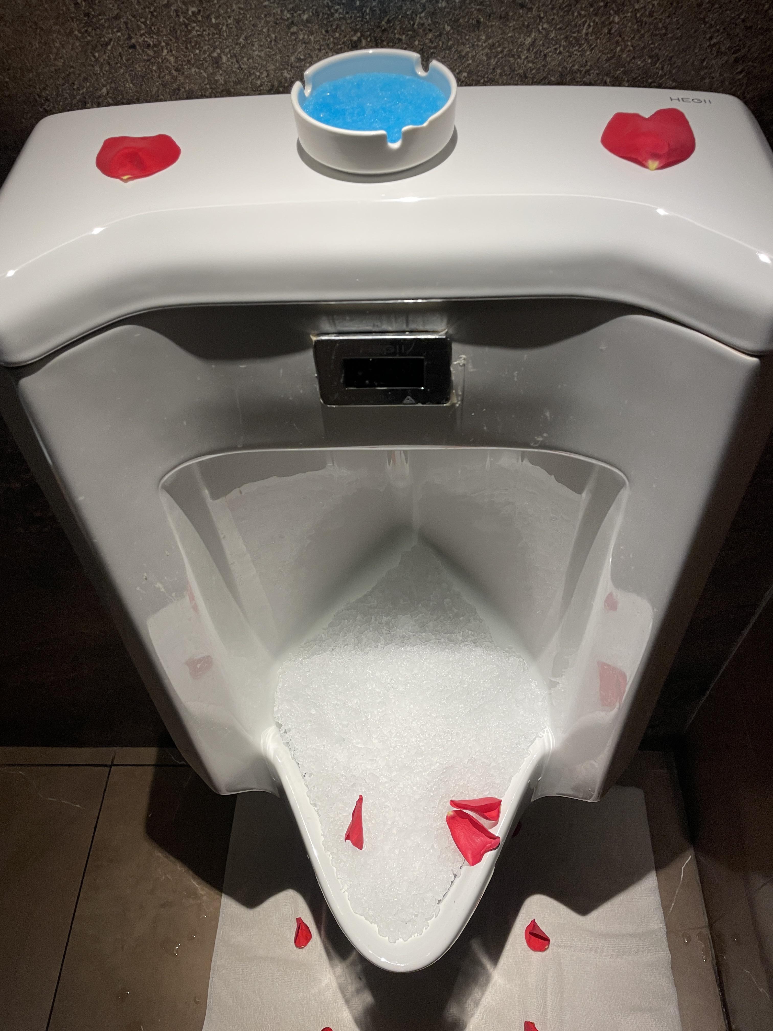 Urinal with rose petals on a bed of crushed ice | Scrolller