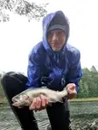 A small stocked rainbow trout caught in a rainstorm