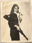 Viet Cong fighter with a captured M1 Carbine in one hand and a flower in the other, 1960s