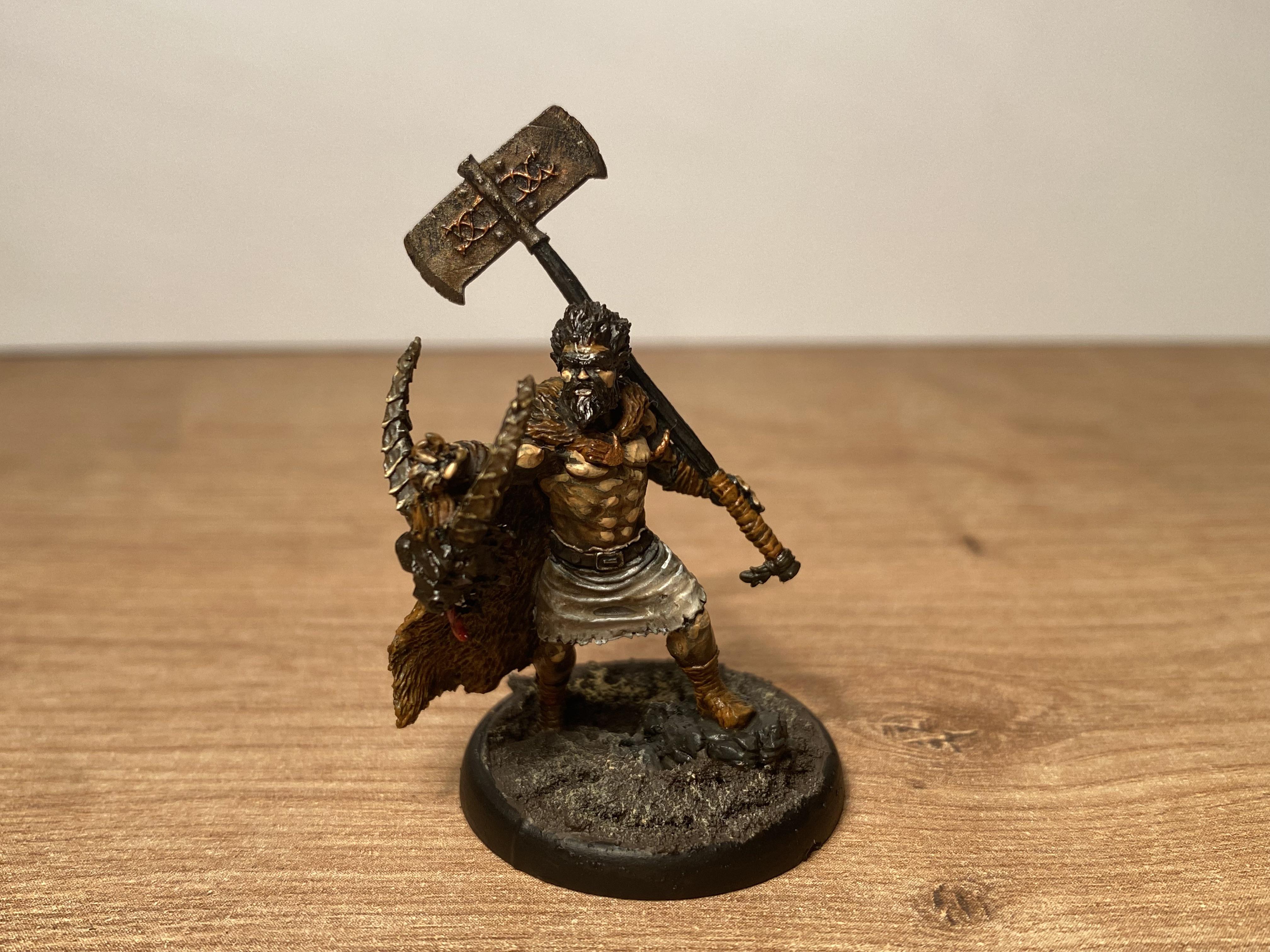 Painted Warhammer miniature of a warrior with a grey beard, tall blue and gold helmet, and an axe on a red base