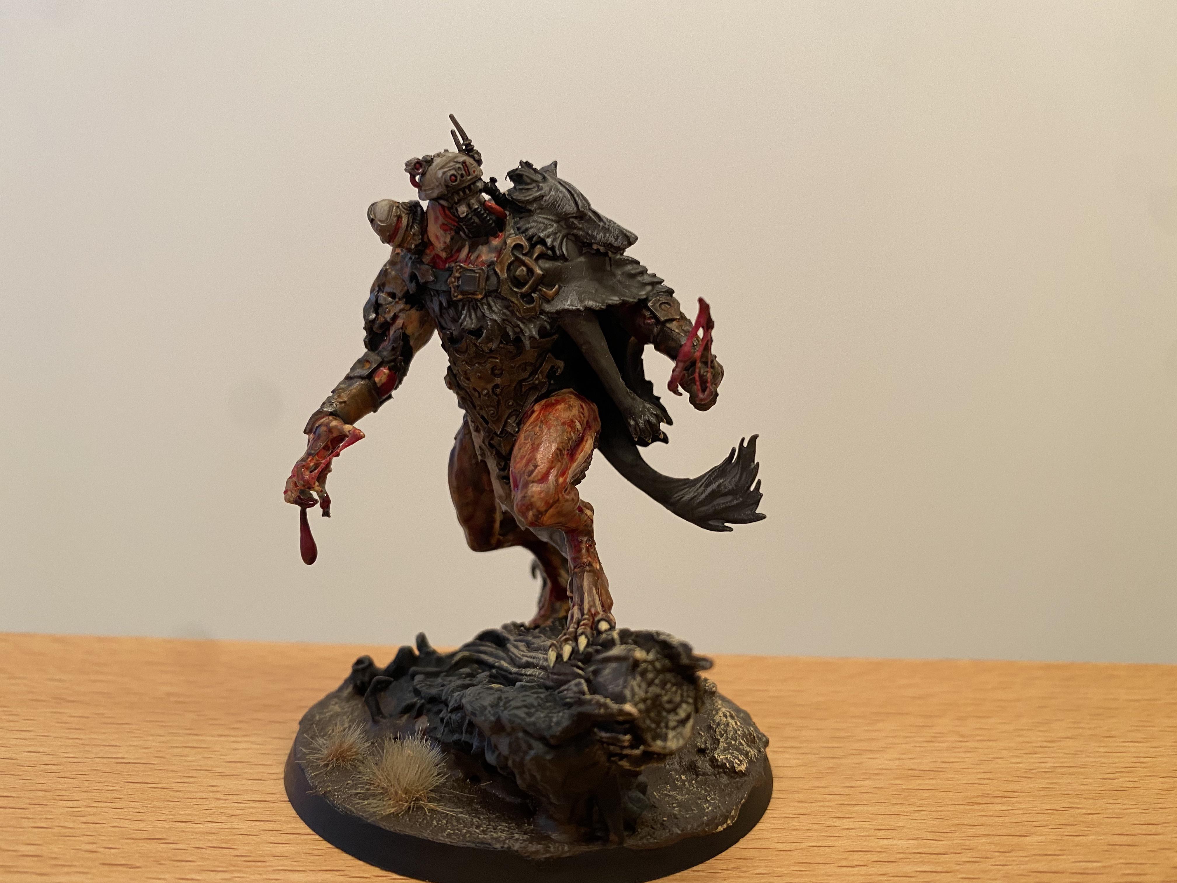Painted Warhammer miniature of a warrior with a grey beard, tall blue and gold helmet, and an axe on a red base