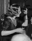 Tallulah Bankhead drinking champagne from her shoe during a press conference at the Ritz Hotel in London (1951)