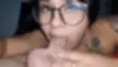 Curvy latina with glasses and a shoulder tattoo giving a deepthroat blowjob with a cumshot