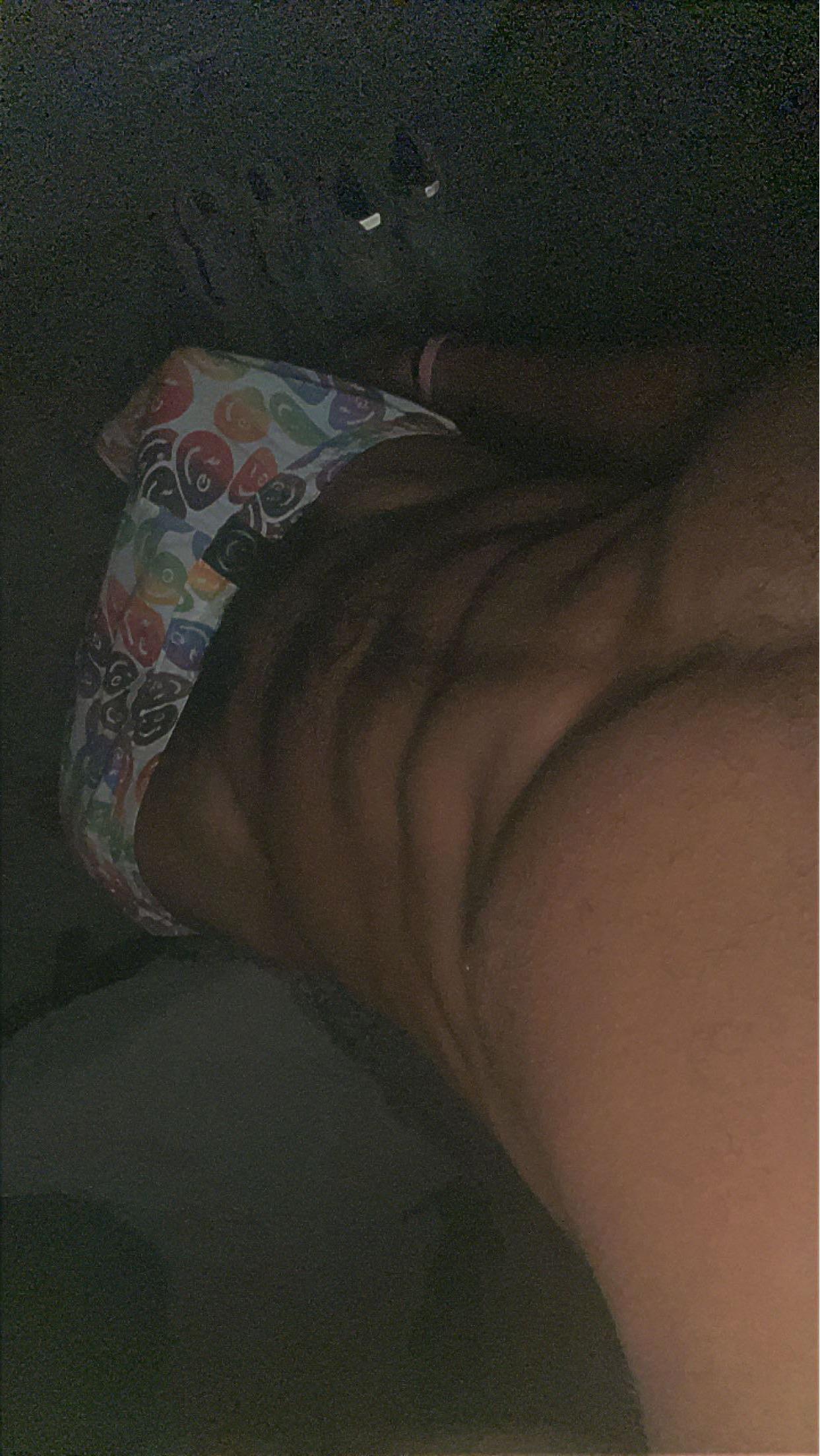 Muscular black man in white Calvin Klein underwear taking a mirror selfie in a bathroom, lifting his grey t-shirt to show abs