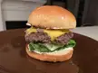 Burger with American cheese, lettuce, onion and pickle