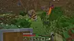Small cute Minecraft house build in a valley with a ruined portal, trees, and grass.