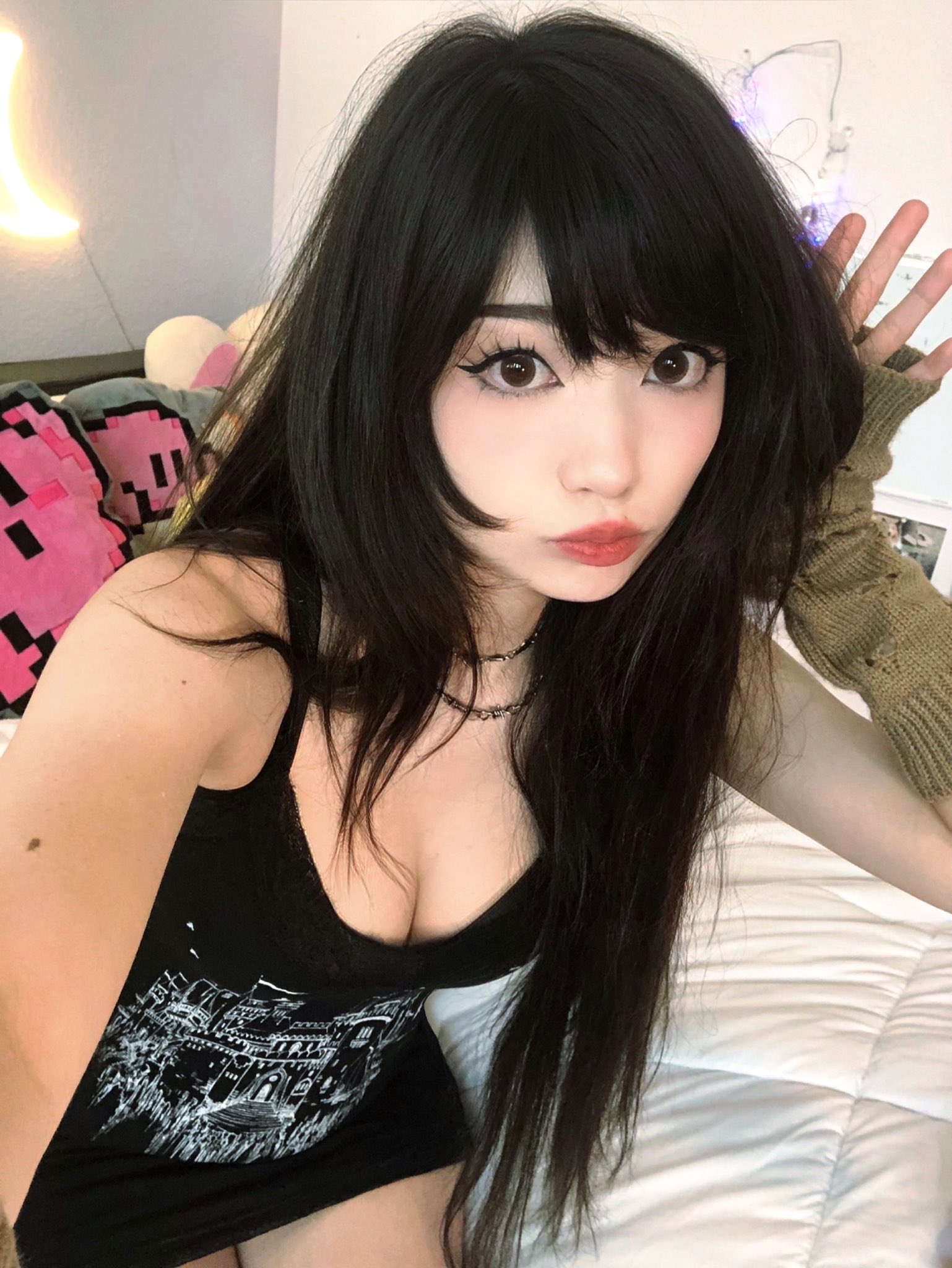 Emiru in a close-up selfie wearing a black lace top and red lipstick