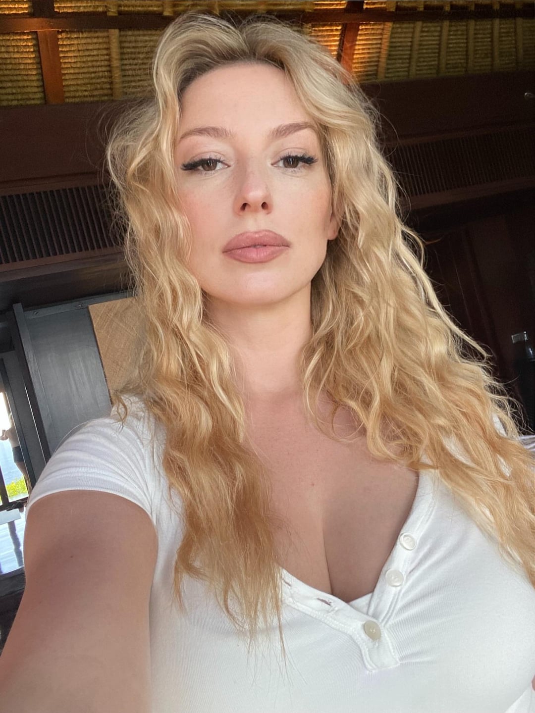 Busty blonde girl next door in a white ribbed shirt selfie