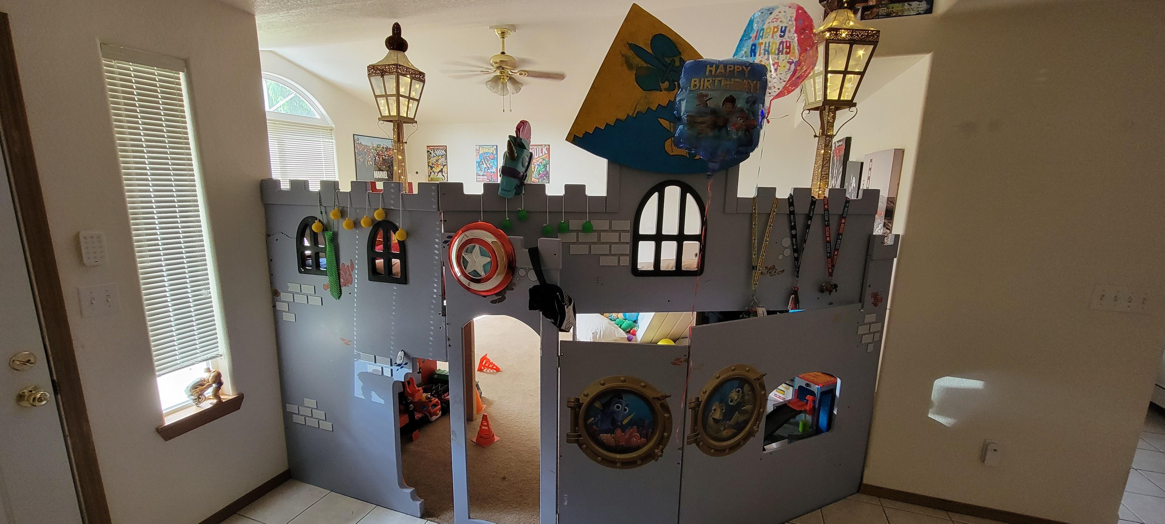 Child's bedroom in Lacey, WA featuring a custom castle bed, lamps, pillows, and stuffed animals.