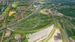 Design of a roundabout at a highway exit with 5 directions. It's got approved to be build in Leuven, Belgium. It has a bike path underneath and lots of greenery and some water.