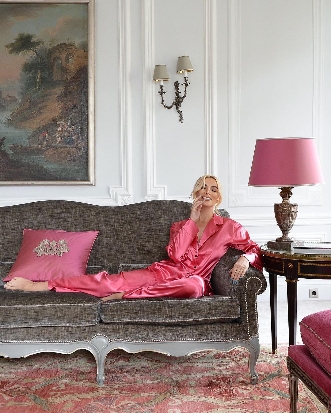 Katerina Kainourgiou posing in a long green ruffled dress and a short purple satin robe