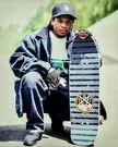 Eazy E with a rare natas skateboard deck that was banned from all skate shops, he had the deck in his trunk and pulled it out for this photo. 1990s