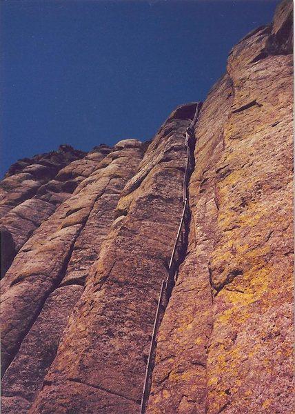 Devils Tower- wooden ladder first used in 1893 by W. Rogers and W. Ripley to climb the 865 feet to the top. The upper section is still visible, being held only by wooden pegs in the cracks of the rock. The lower section was removed in the 1970s. Photo credit to "The Mountain Project". 