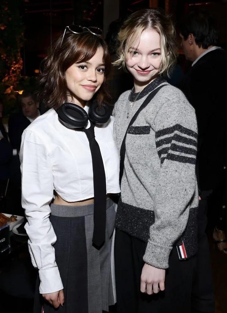 Interracial duo of a slim latina woman in a white crop top and a slim blonde white woman in a grey sweater.