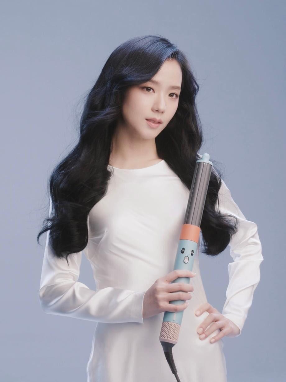 BLACKPINK’s Jisoo in a white dress posing with a Dyson hair curling iron