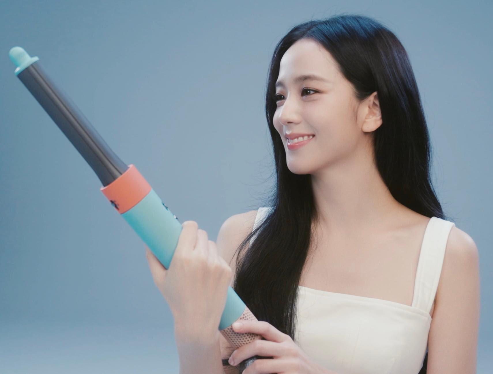 BLACKPINK’s Jisoo in a white dress posing with a Dyson hair curling iron
