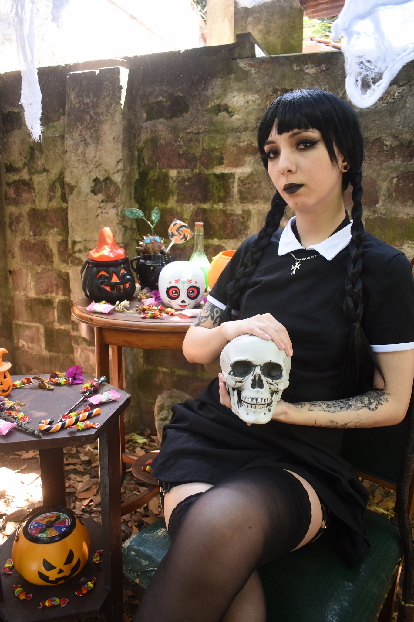 Katss_kawaii as a goth girl in a black maid dress and garter belt posing in a Halloween garden