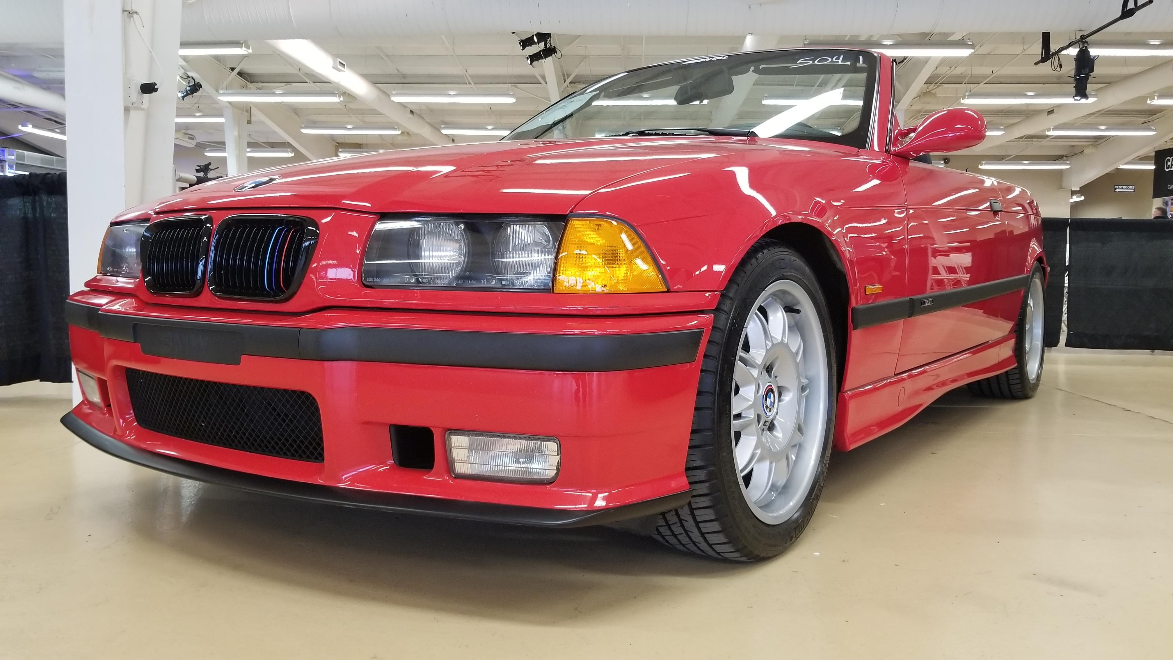 Red BMW E36 M3 cabrio in an indoor showroom, including a close-up of the M3 badge.