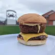 Guiding Forces: 6oz smash patty, American cheese, panko-crusted deep fried green chile mac n cheese, tomato slice, and mayo on a toasted bun