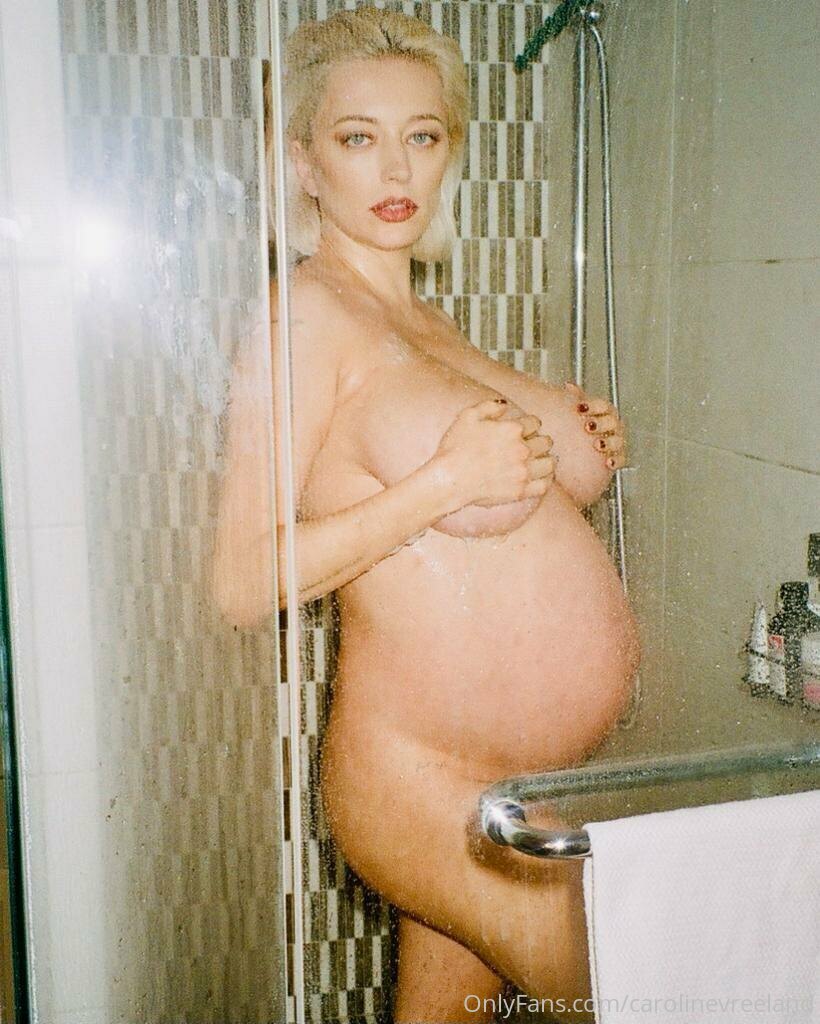 Caroline Vreeland posing nude and pregnant in a shower with a glass of wine