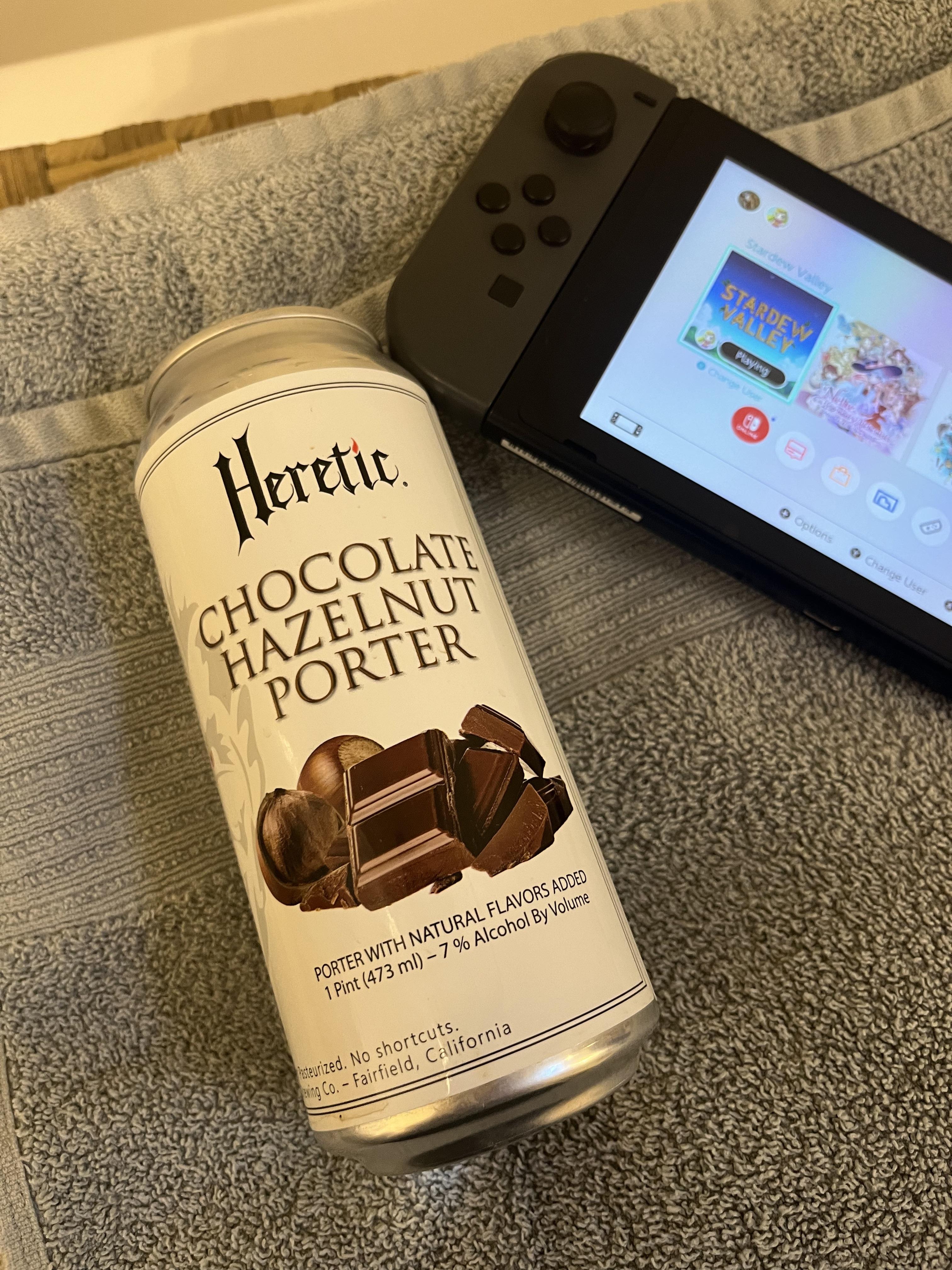 Busty blonde woman taking a shower beer in a bubble bath with a Nintendo Switch and Heretic Chocolate Hazelnut Porter