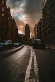 Unexpected beautiful sunset light on a city street with brick buildings and a church tower
