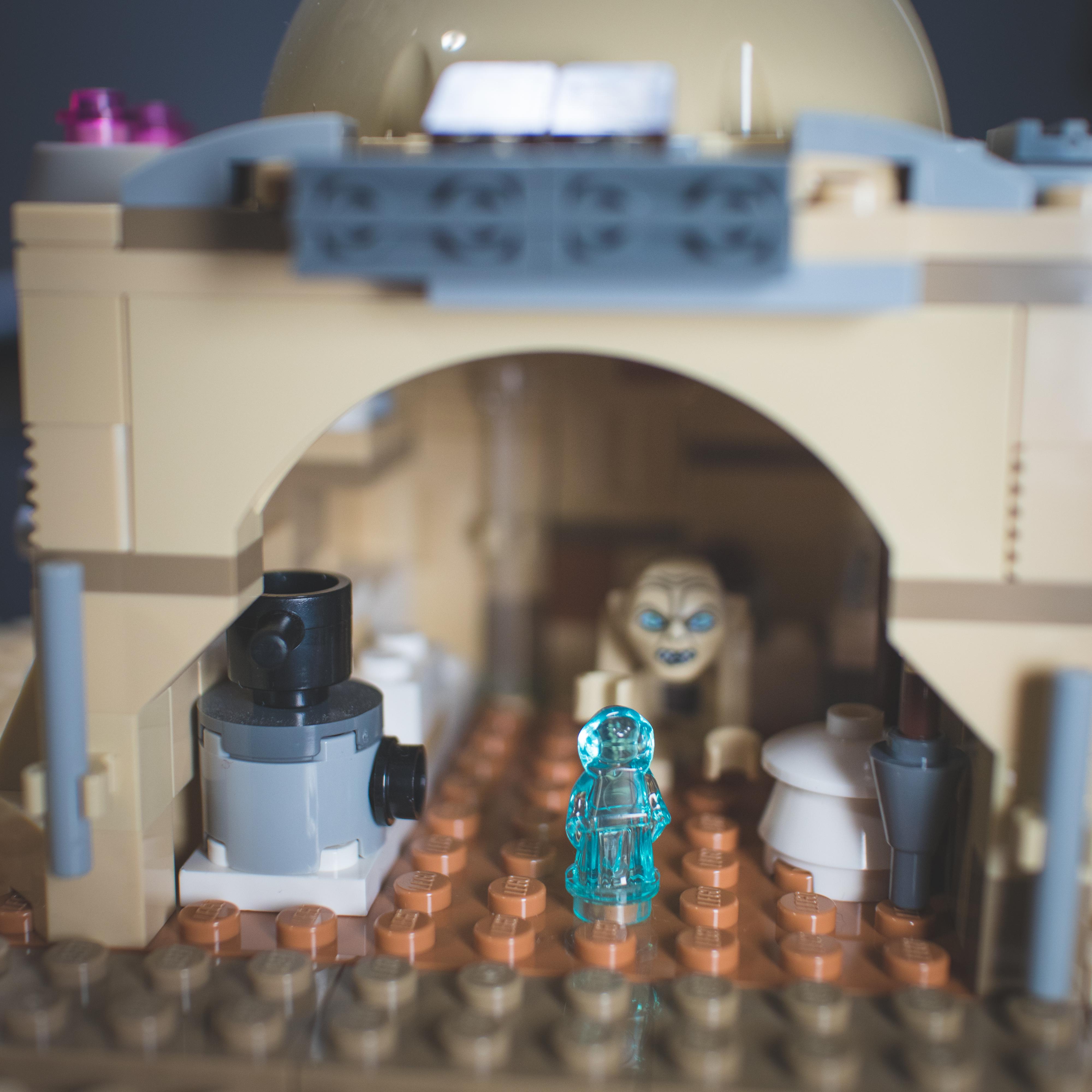 LEGO Star Wars minifigures and buildings in a Mos Eisley Cantina desert scene with a pirate flag and spaceship
