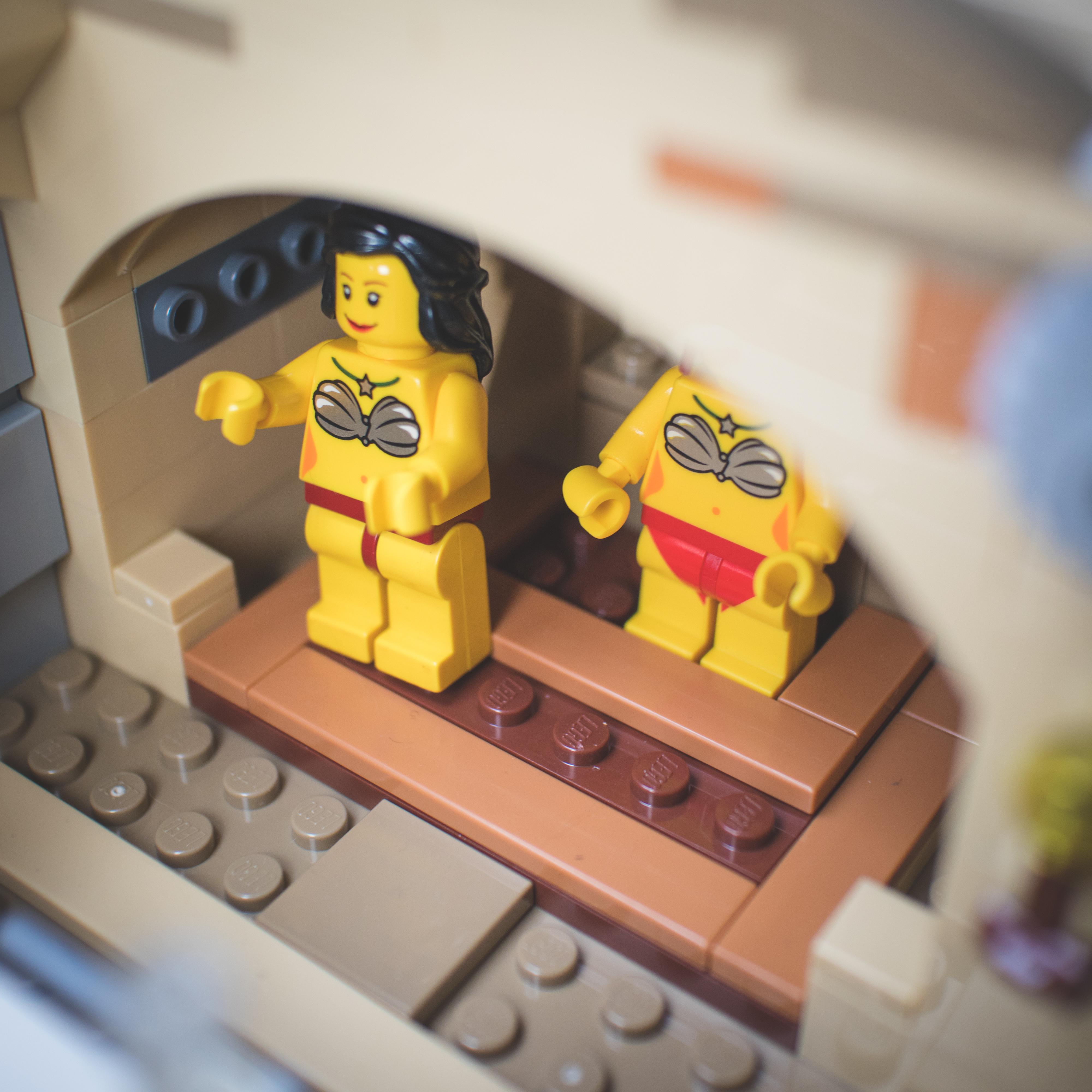 LEGO Star Wars minifigures and buildings in a Mos Eisley Cantina desert scene with a pirate flag and spaceship