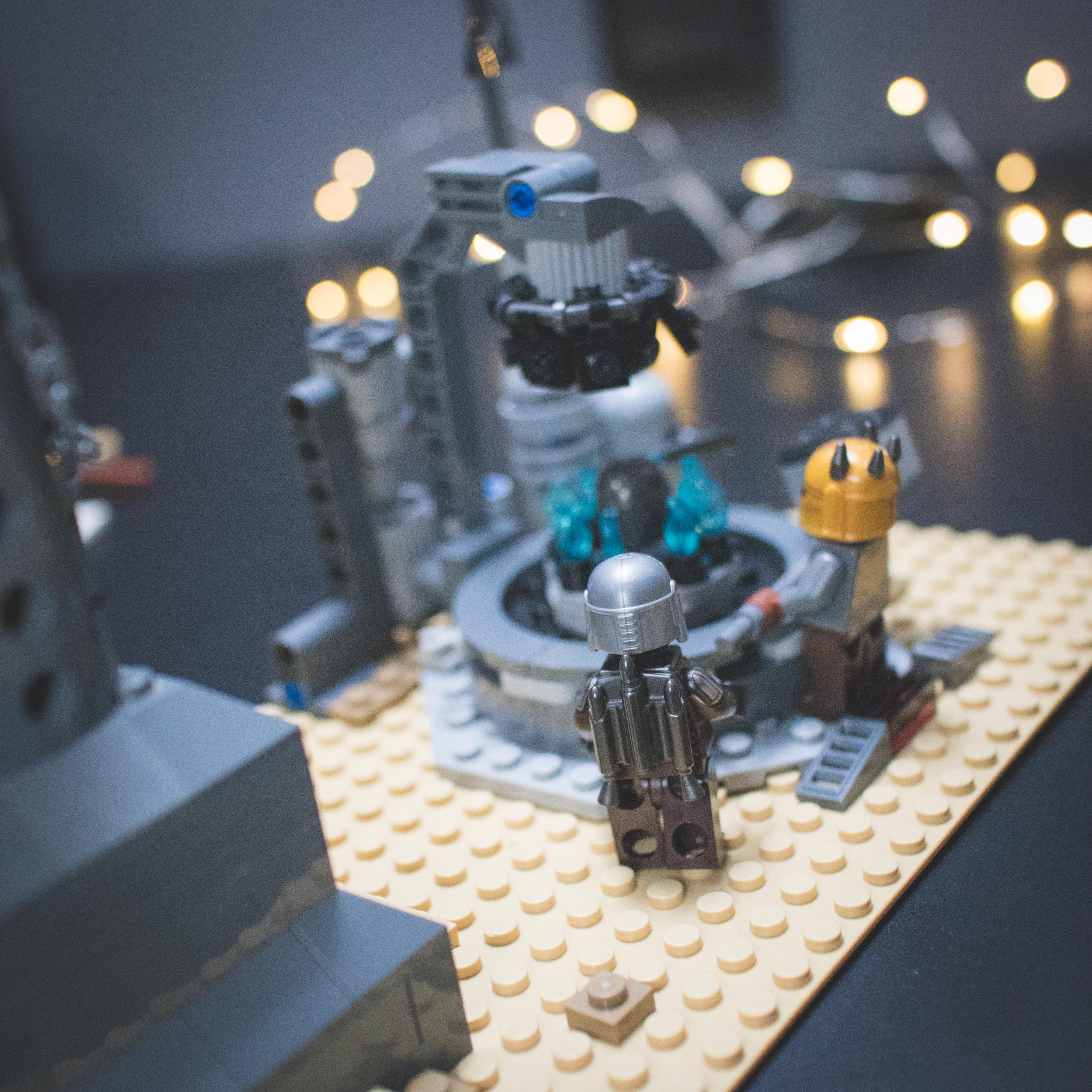 LEGO Star Wars minifigures and buildings in a Mos Eisley Cantina desert scene with a pirate flag and spaceship