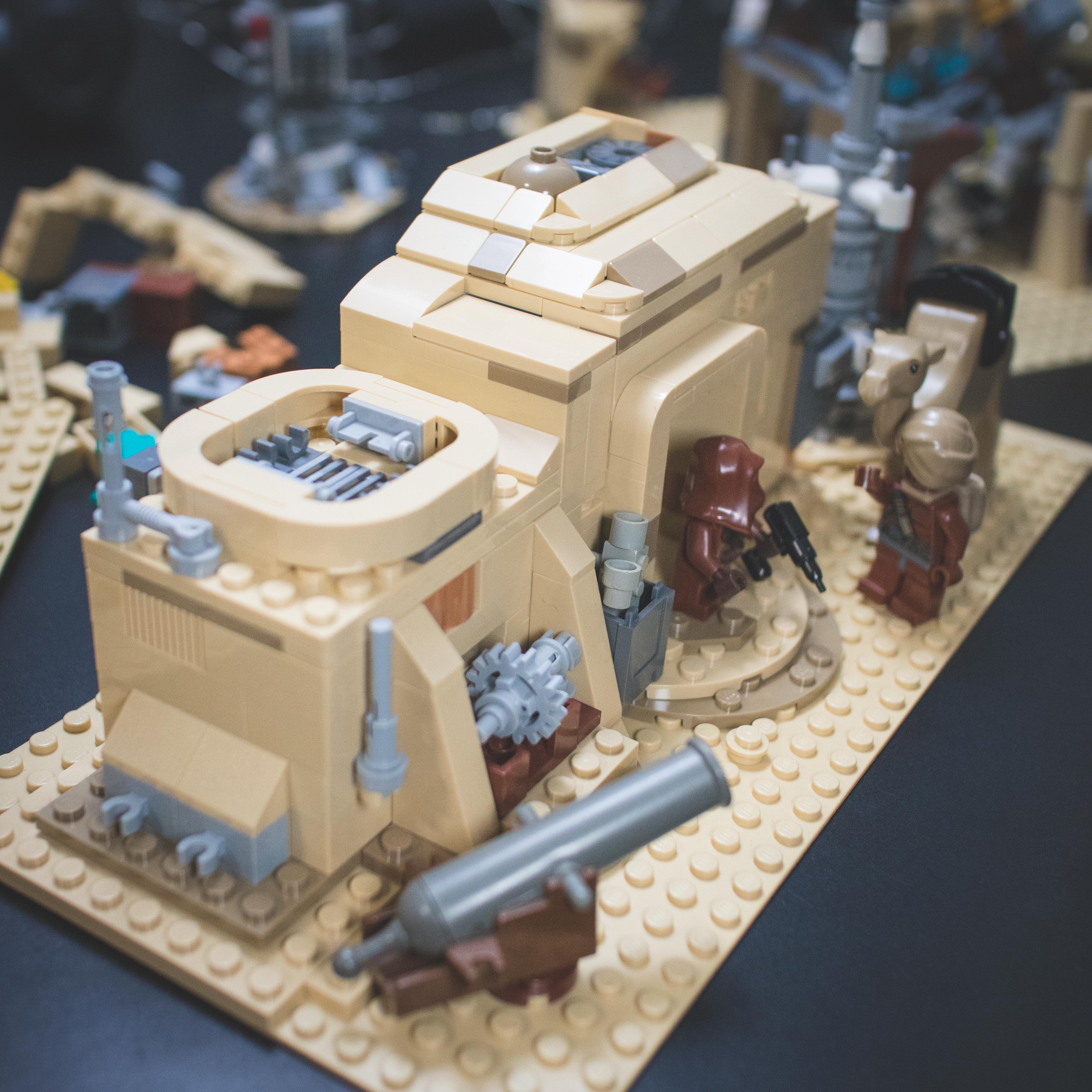 LEGO Star Wars minifigures and buildings in a Mos Eisley Cantina desert scene with a pirate flag and spaceship