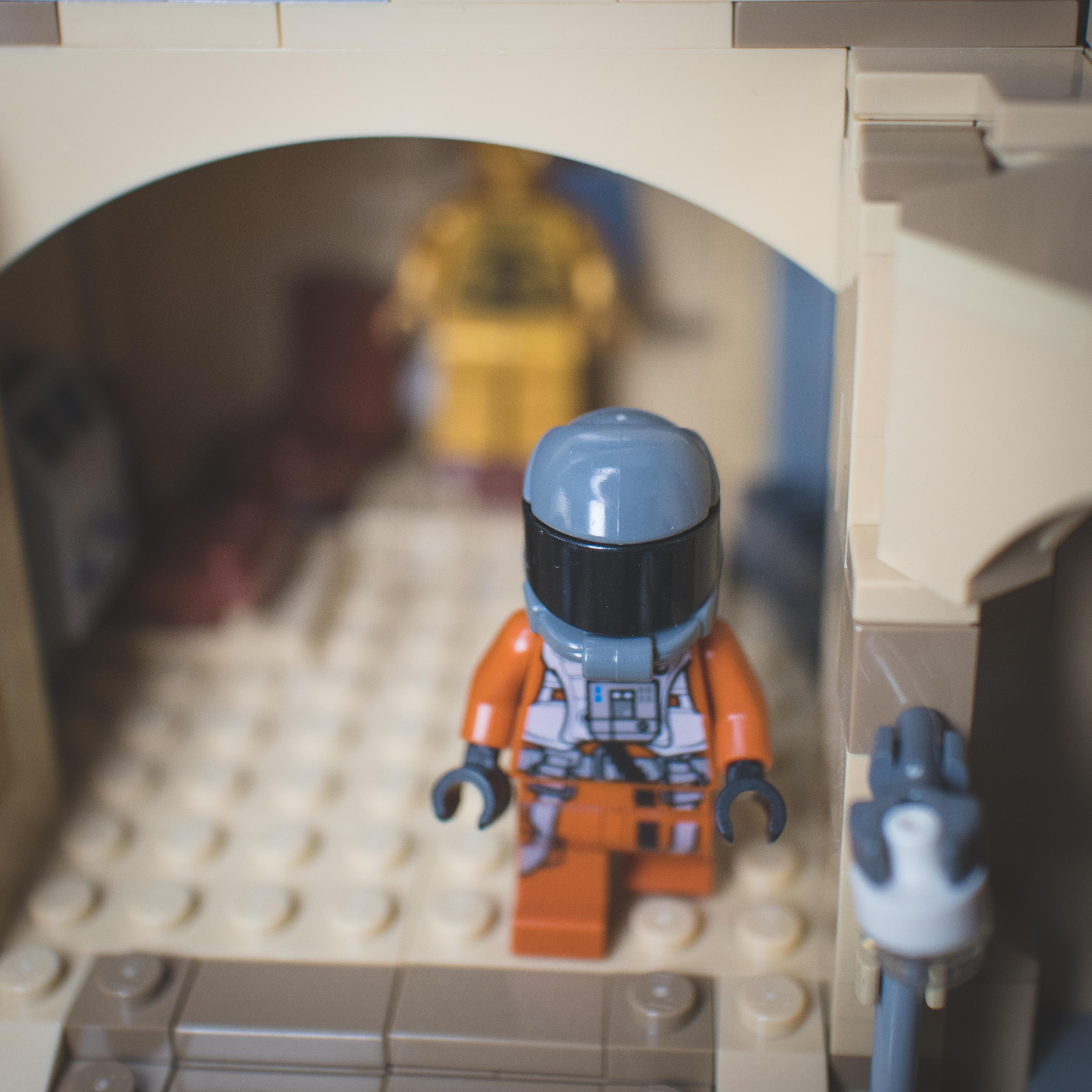 LEGO Star Wars minifigures and buildings in a Mos Eisley Cantina desert scene with a pirate flag and spaceship