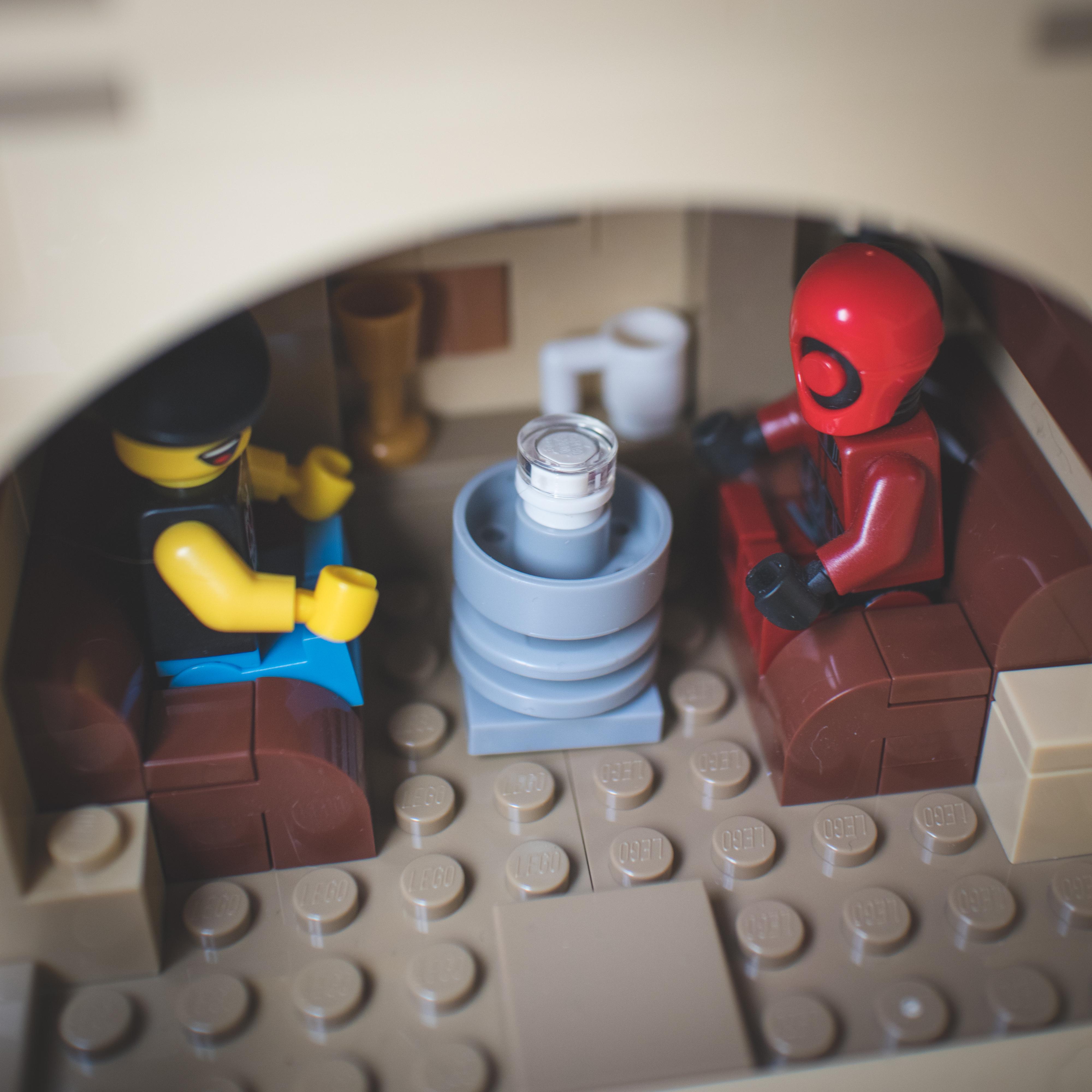 LEGO Star Wars minifigures and buildings in a Mos Eisley Cantina desert scene with a pirate flag and spaceship