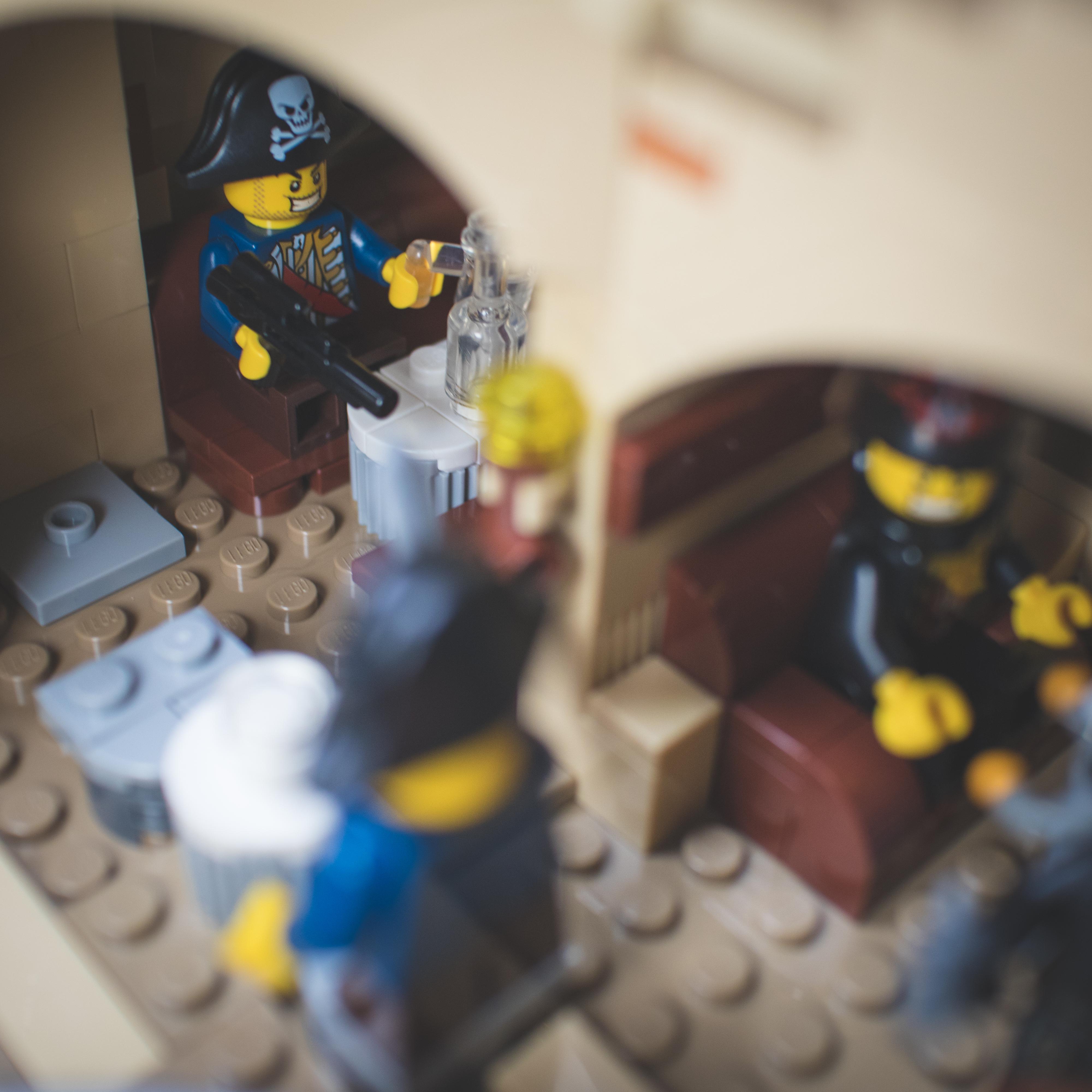 LEGO Star Wars minifigures and buildings in a Mos Eisley Cantina desert scene with a pirate flag and spaceship