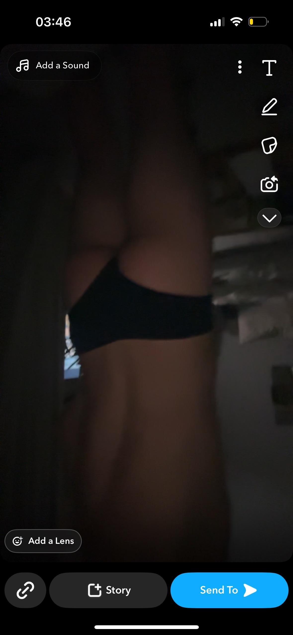Slim tanned boy in black panties standing side view selfie