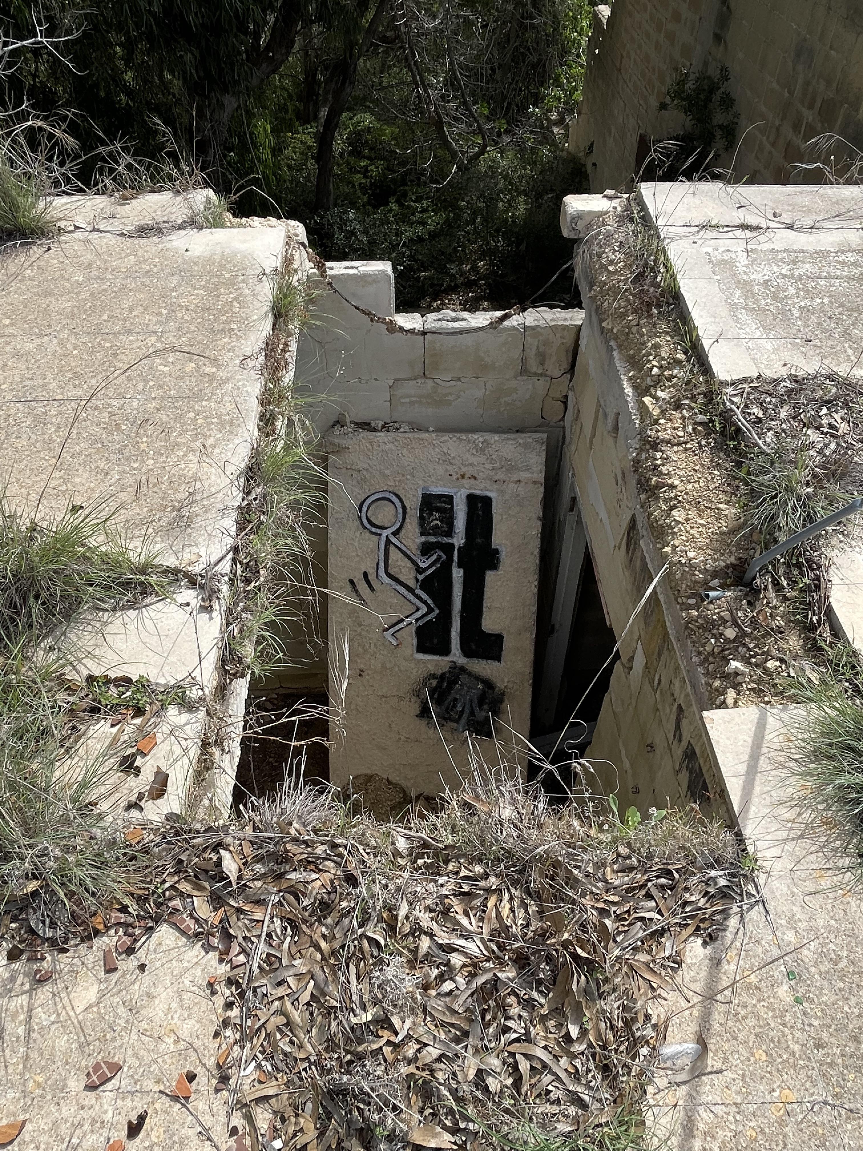 Urban exploration of a derelict 5 storey concrete building in Malta with graffiti and rubble.