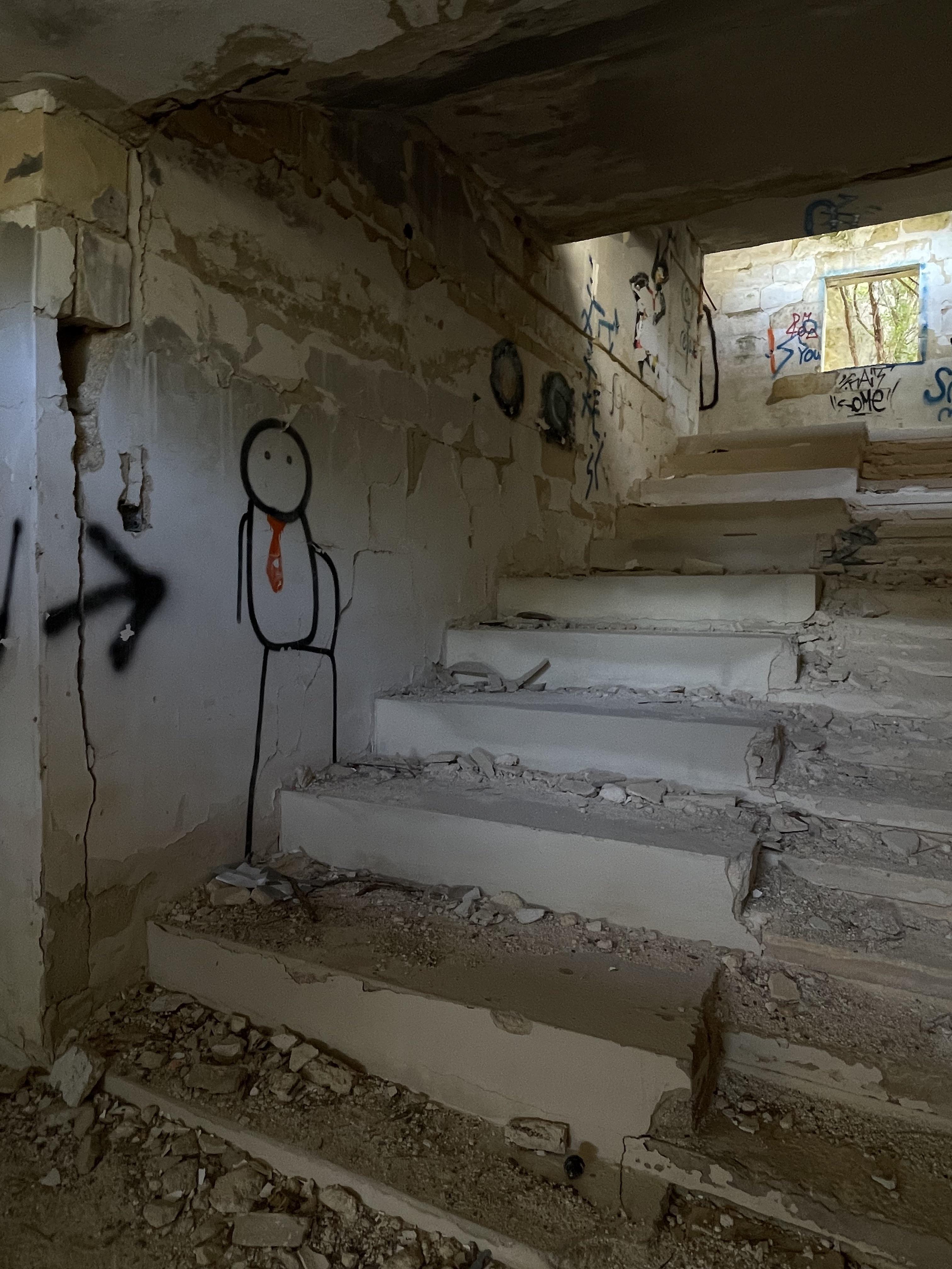 Urban exploration of a derelict 5 storey concrete building in Malta with graffiti and rubble.