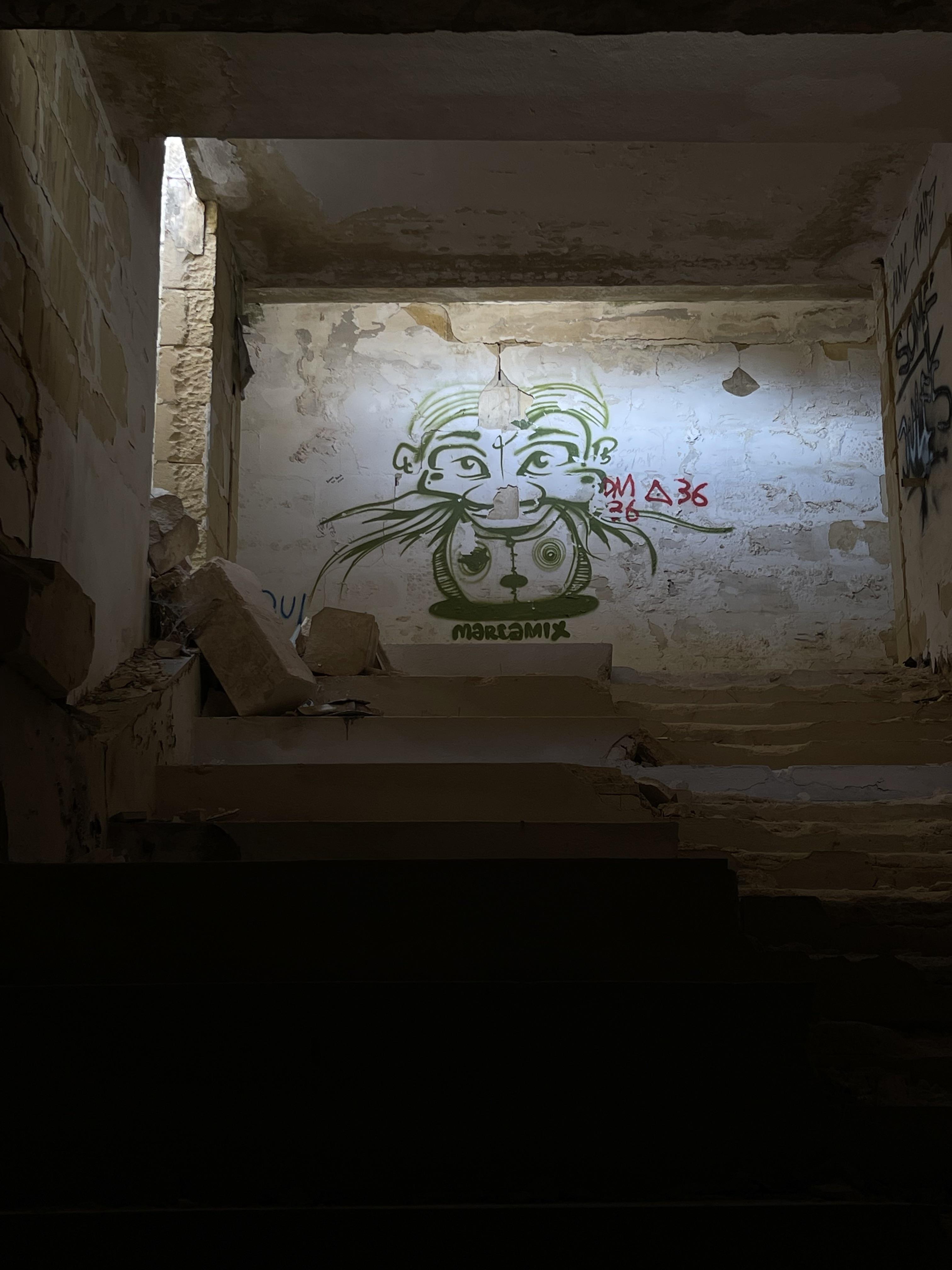 Urban exploration of a derelict 5 storey concrete building in Malta with graffiti and rubble.