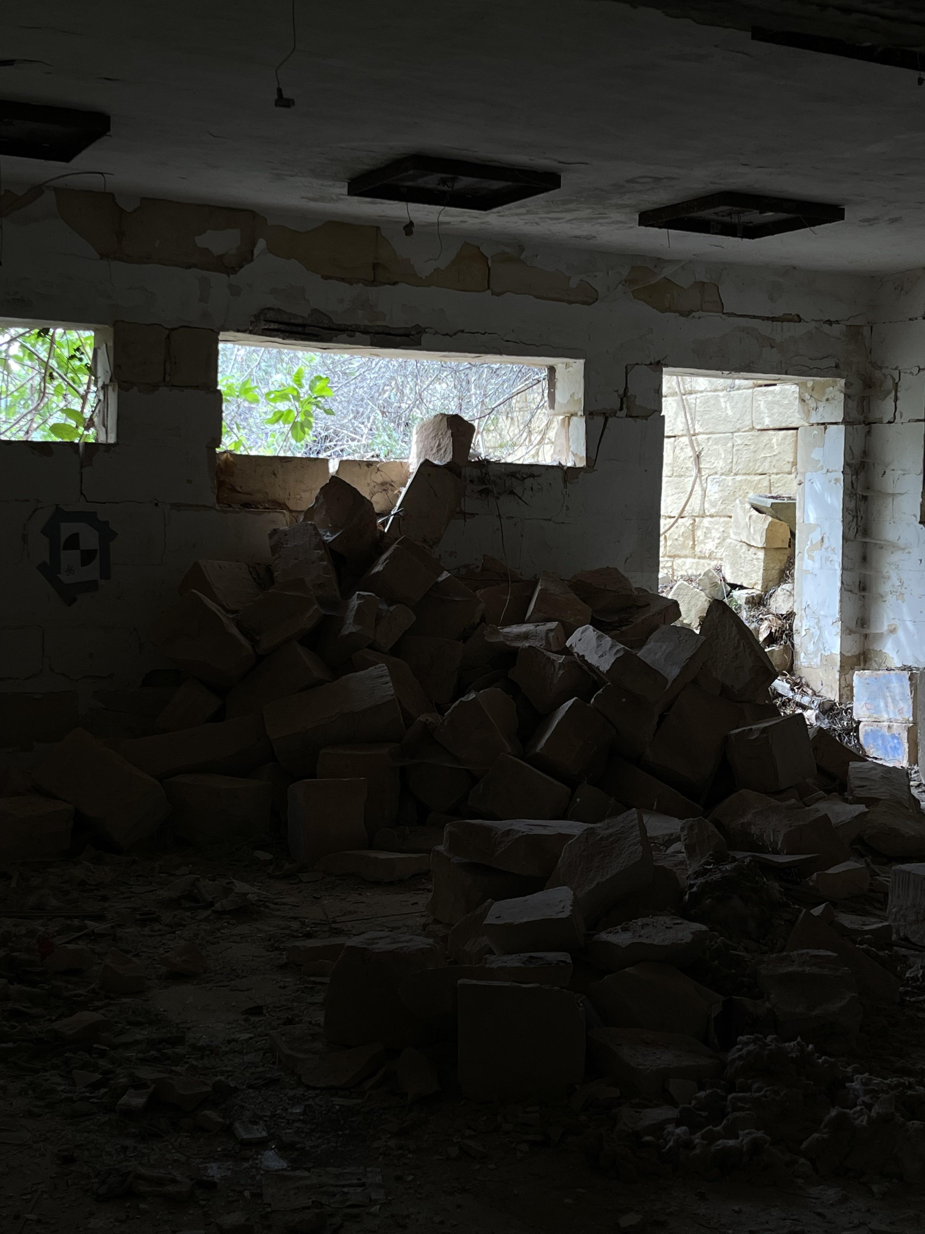 Urban exploration of a derelict 5 storey concrete building in Malta with graffiti and rubble.