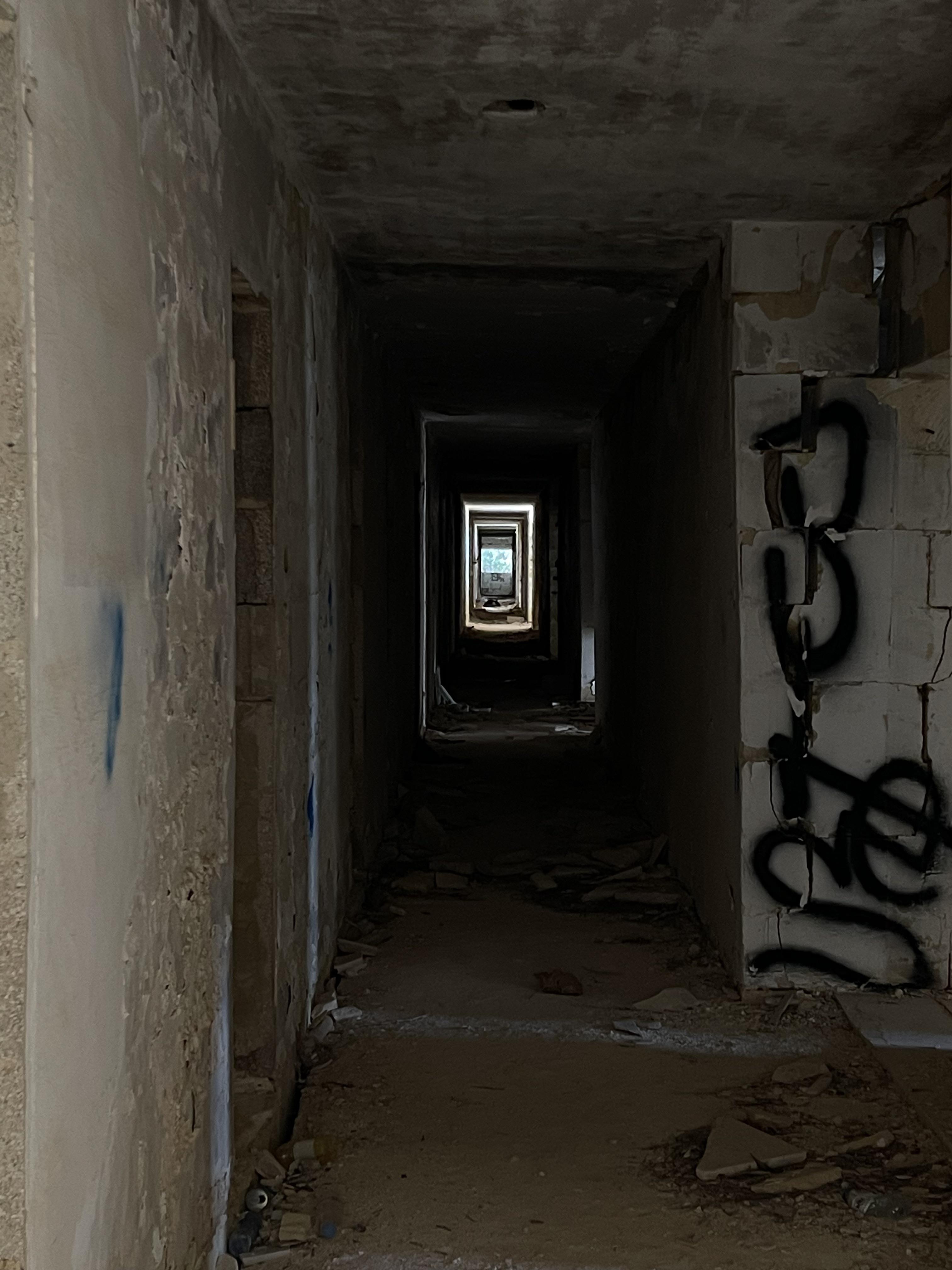 Urban exploration of a derelict 5 storey concrete building in Malta with graffiti and rubble.