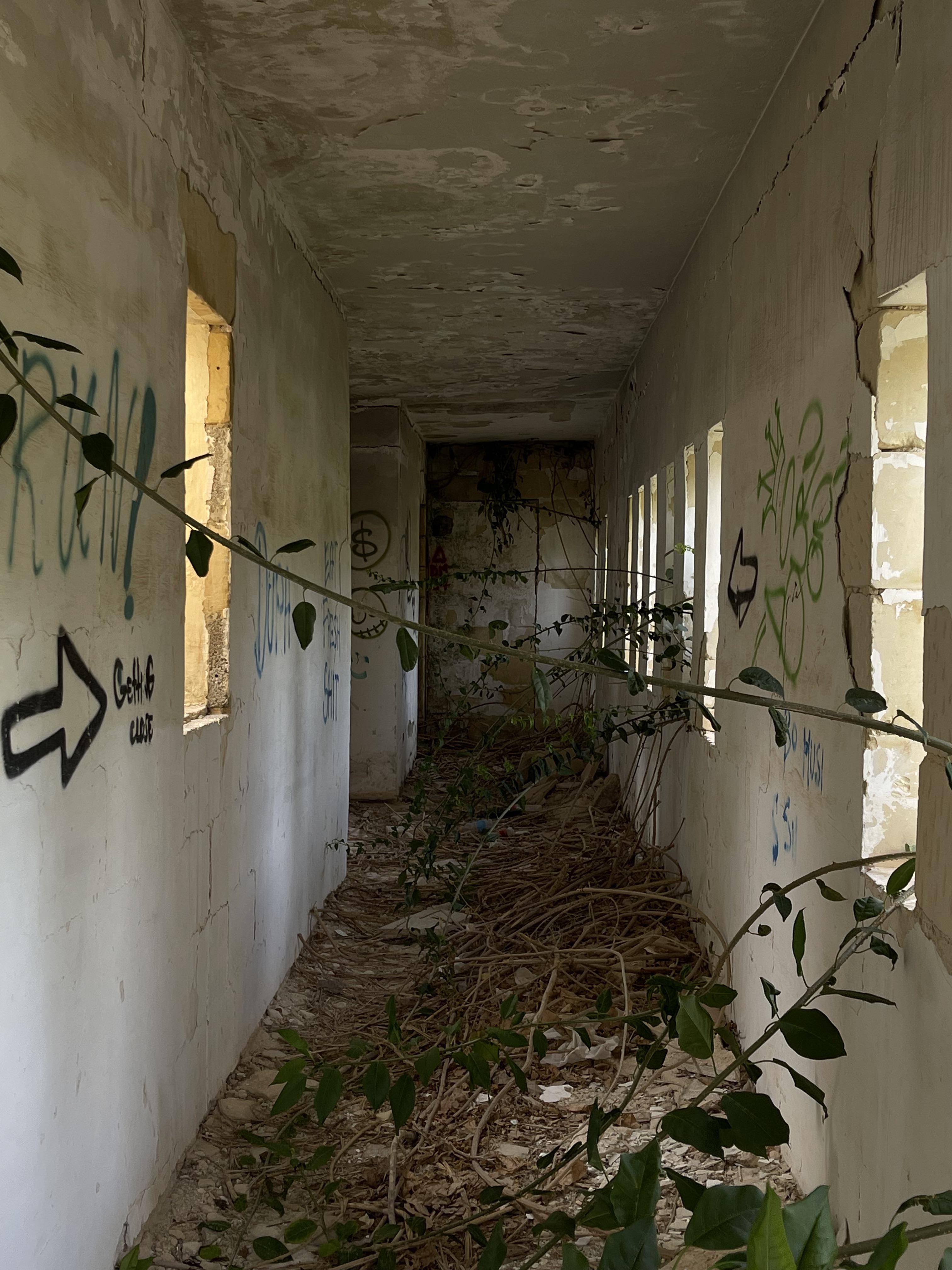 Urban exploration of a derelict 5 storey concrete building in Malta with graffiti and rubble.
