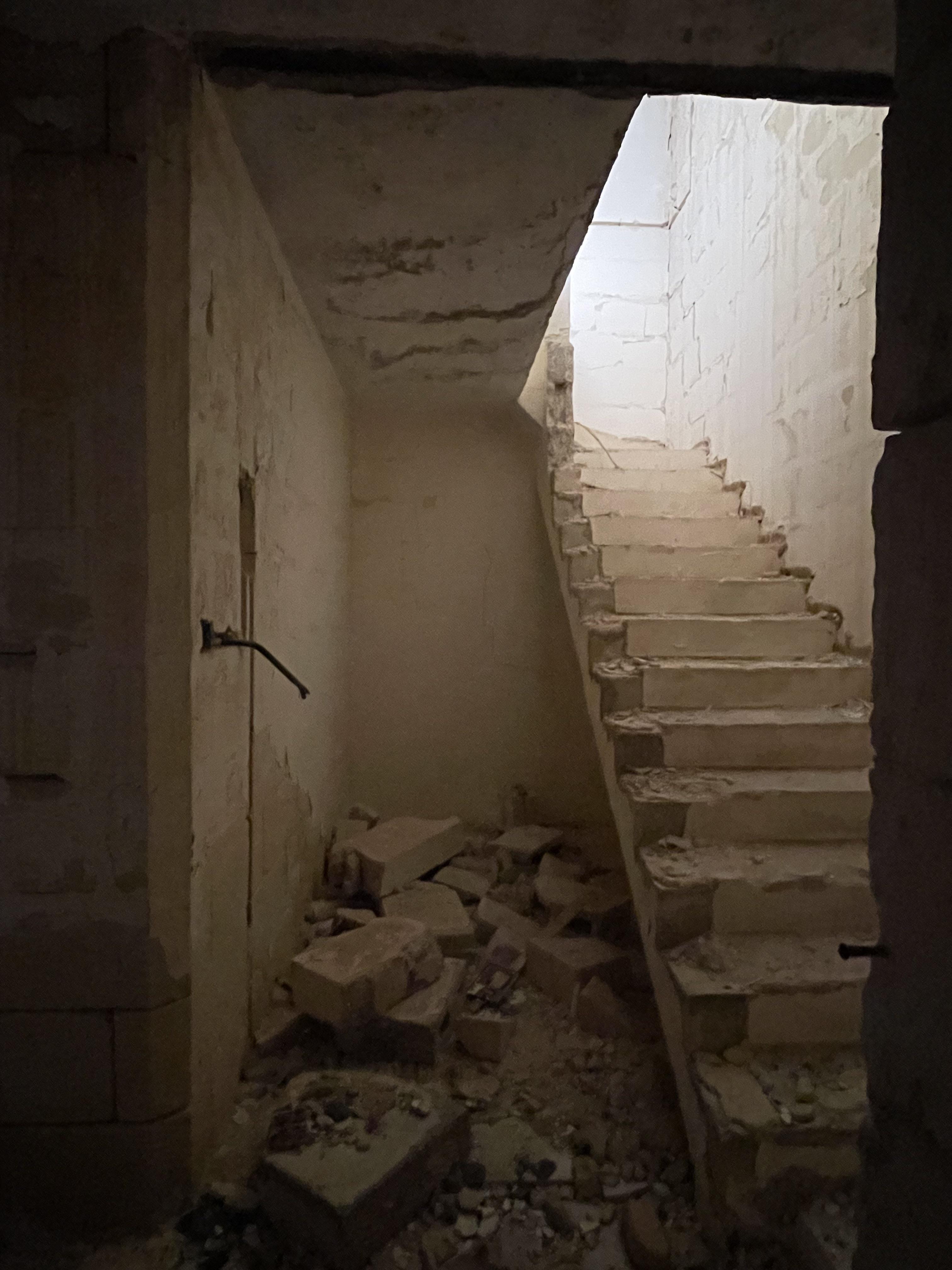 Urban exploration of a derelict 5 storey concrete building in Malta with graffiti and rubble.