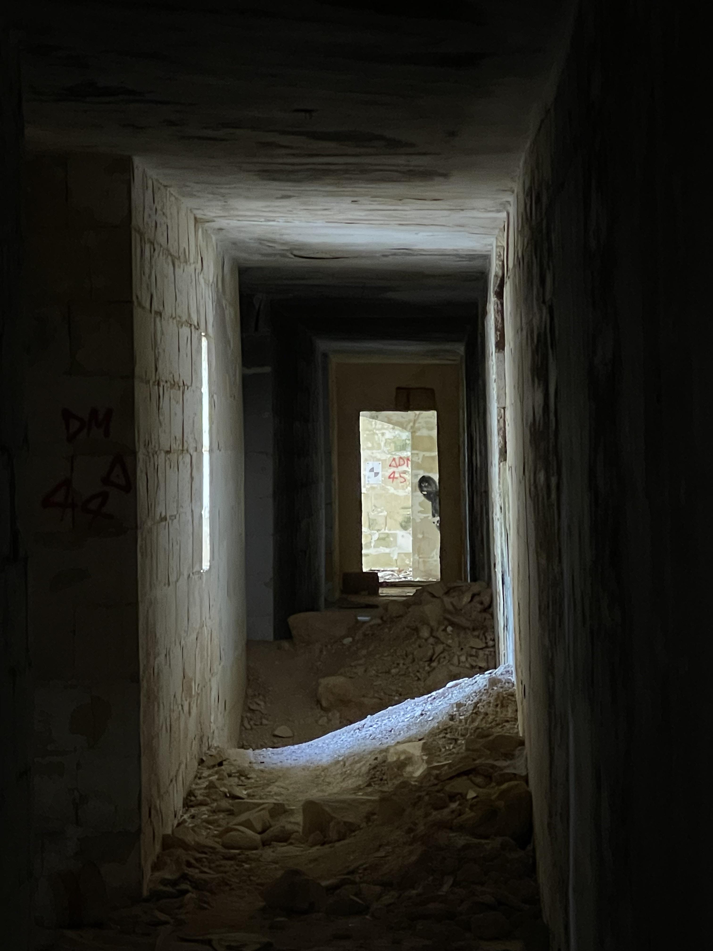 Urban exploration of a derelict 5 storey concrete building in Malta with graffiti and rubble.