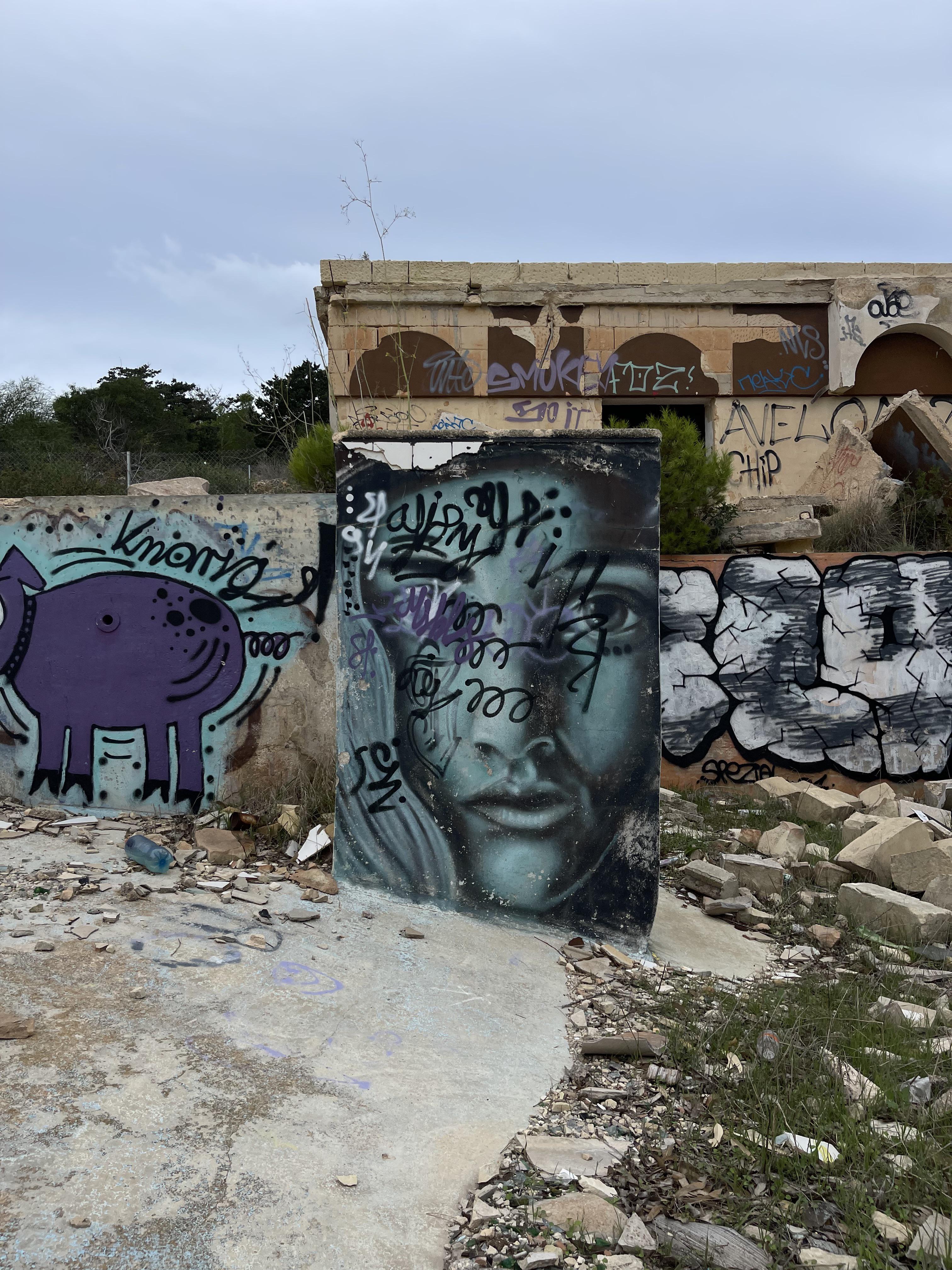 Urban exploration of a derelict 5 storey concrete building in Malta with graffiti and rubble.