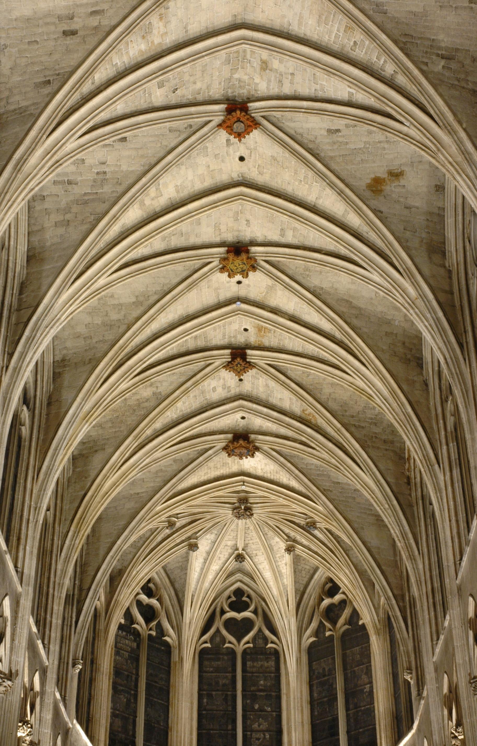 Medieval Minecraft builds featuring vaulted ceilings and stone walls with a group of people.